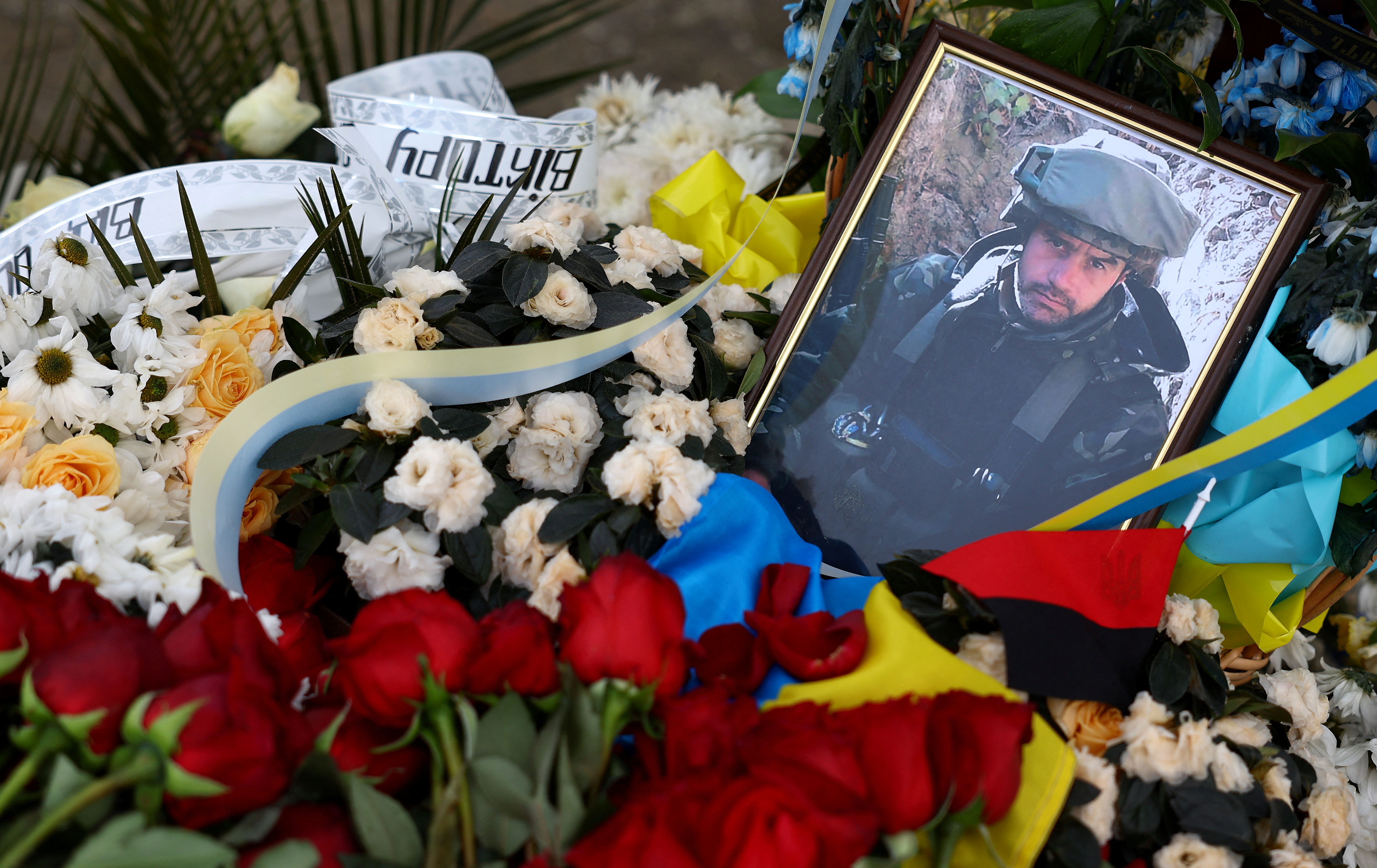Picture of Ukrainian serviceman Victor Dudar is seen amongst flowers on his grave at the military part of the cemetery in Lviv