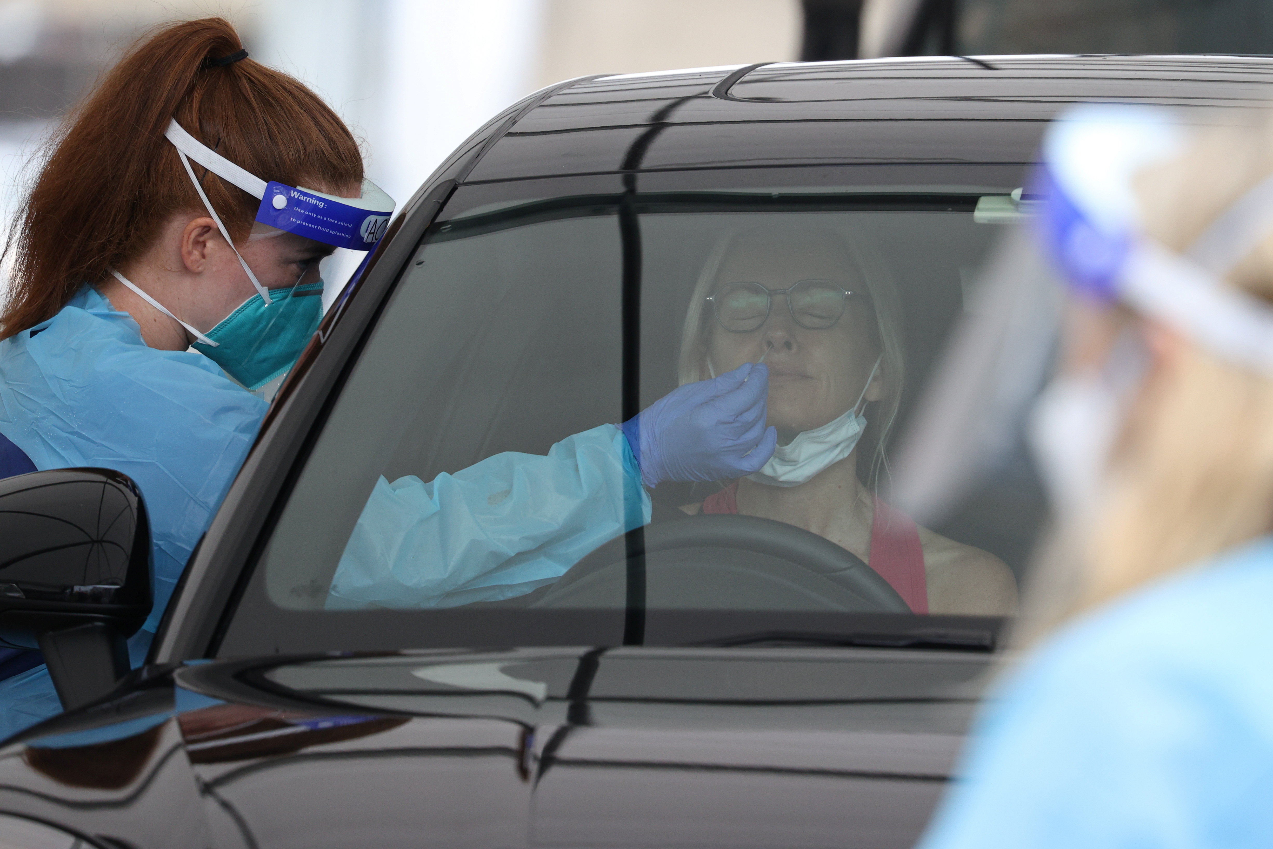 A medical worker swabs a member of the public at a drive-through COVID-19 testing centre in Sydney