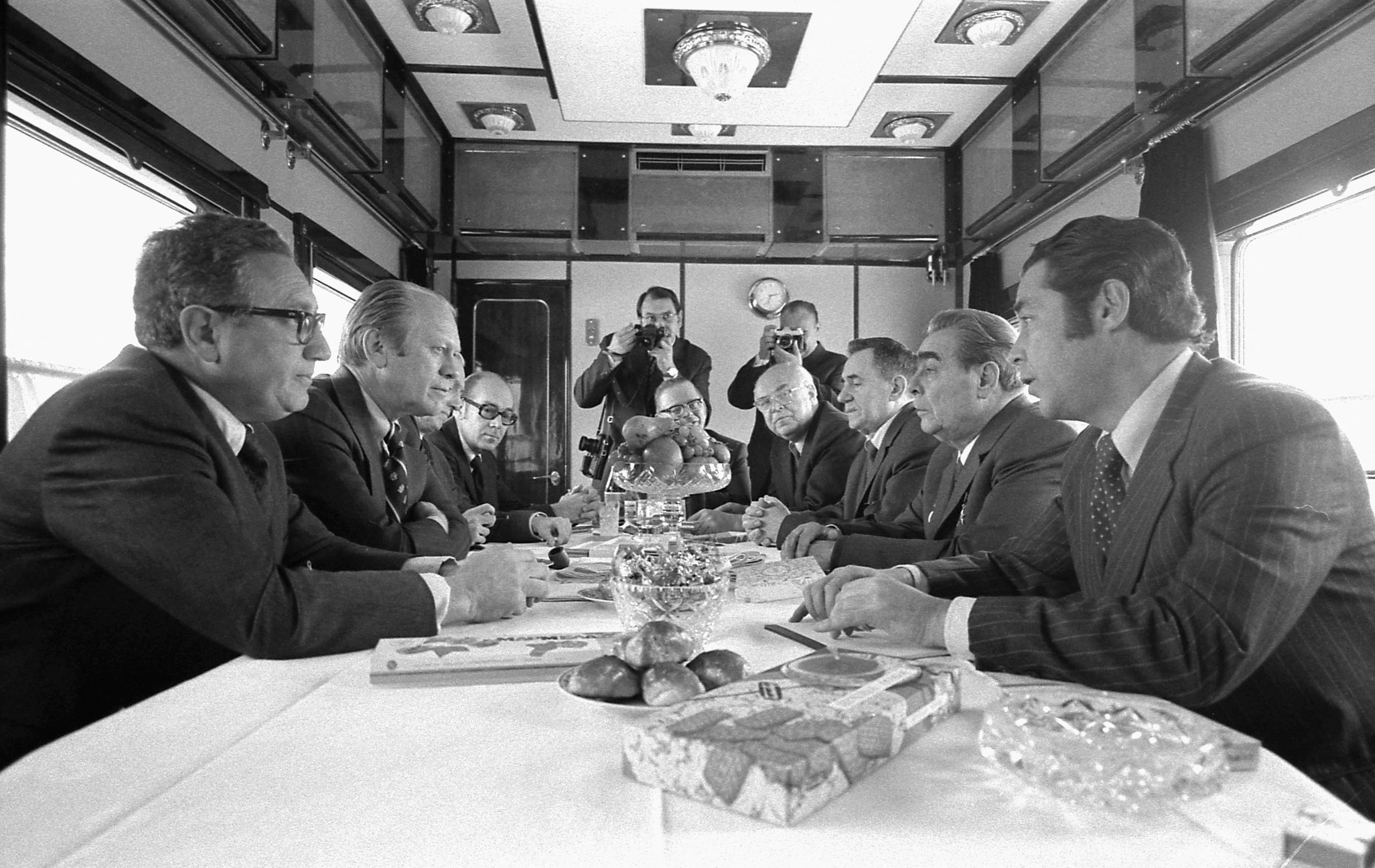 1974年11月23日、ロシアのウラジオストクに向かうロシア列車の中で、ジェラルド・フォード米国大統領、ヘンリー・キッシンジャー国務長官およびその他の米国代表者らがソ連のブレジネフ書記長、グロムイコ外務大臣、ドブリニン大使らと会談する。 ジェラルド・R・フォード図書館/ロイター経由 