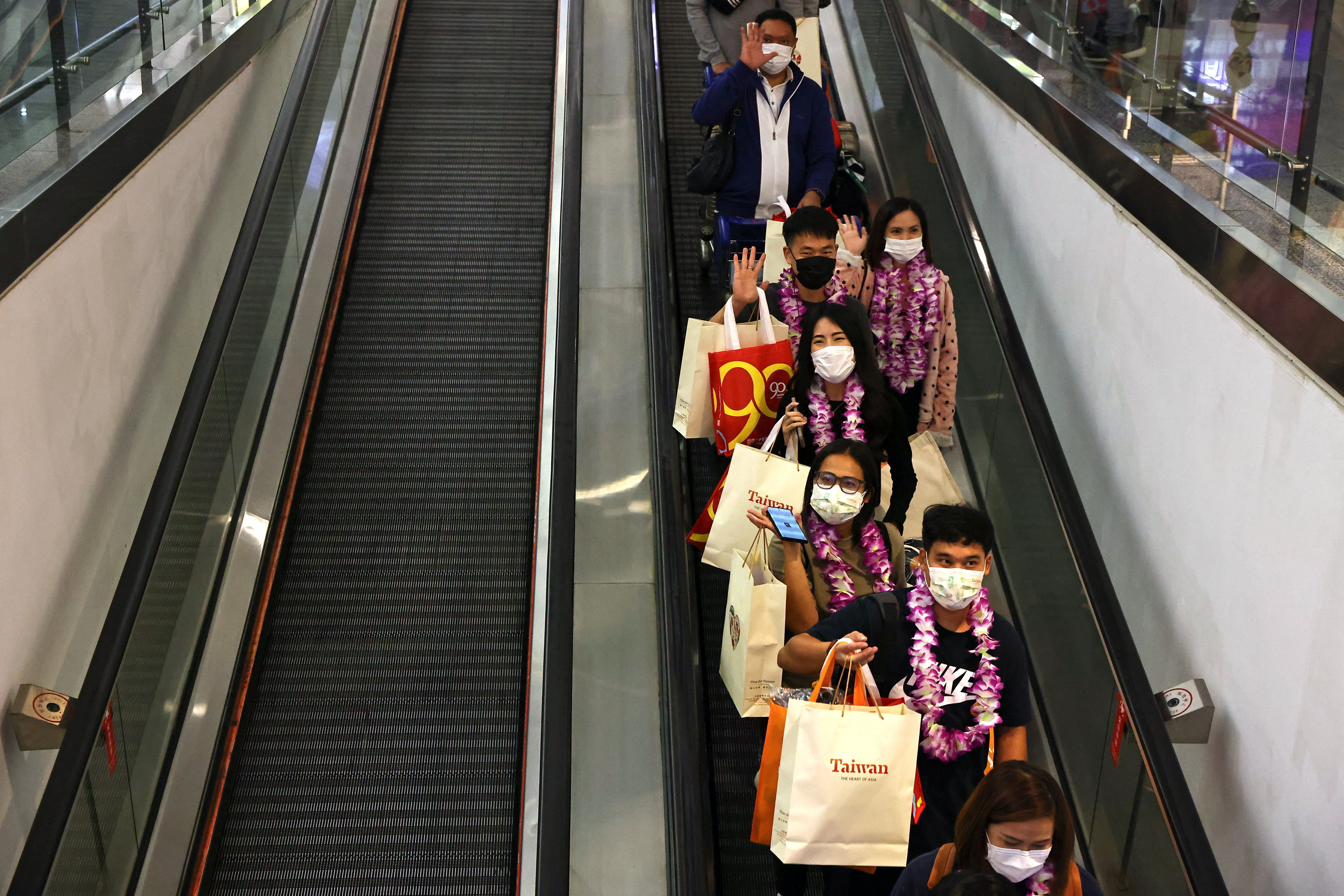 Travellers from Thailand on the first quarantine-free flight to Taiwan prepare to leave the airport in Taoyuan