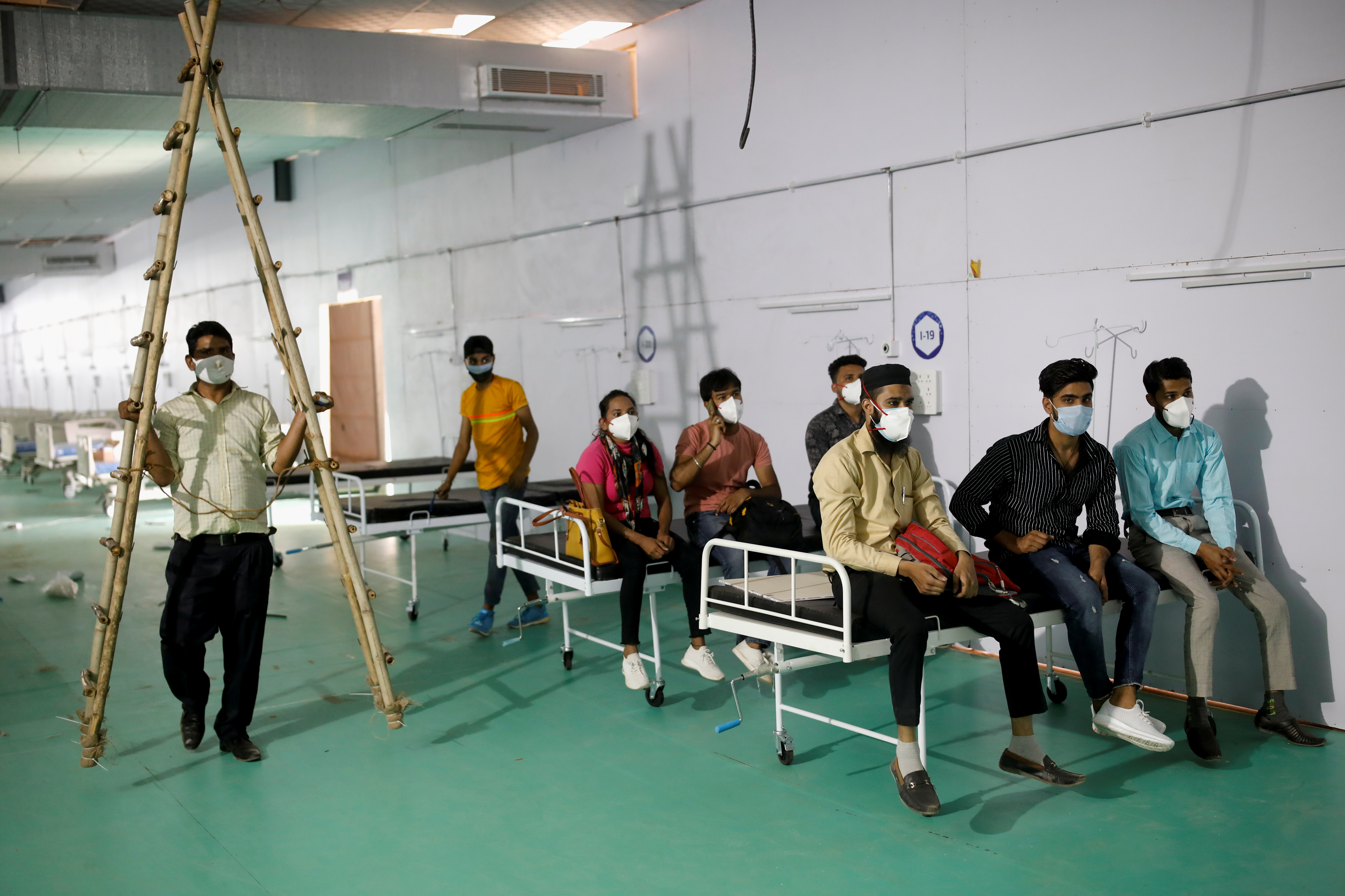 Medical workers listen to a doctor during their briefing, in New Delhi