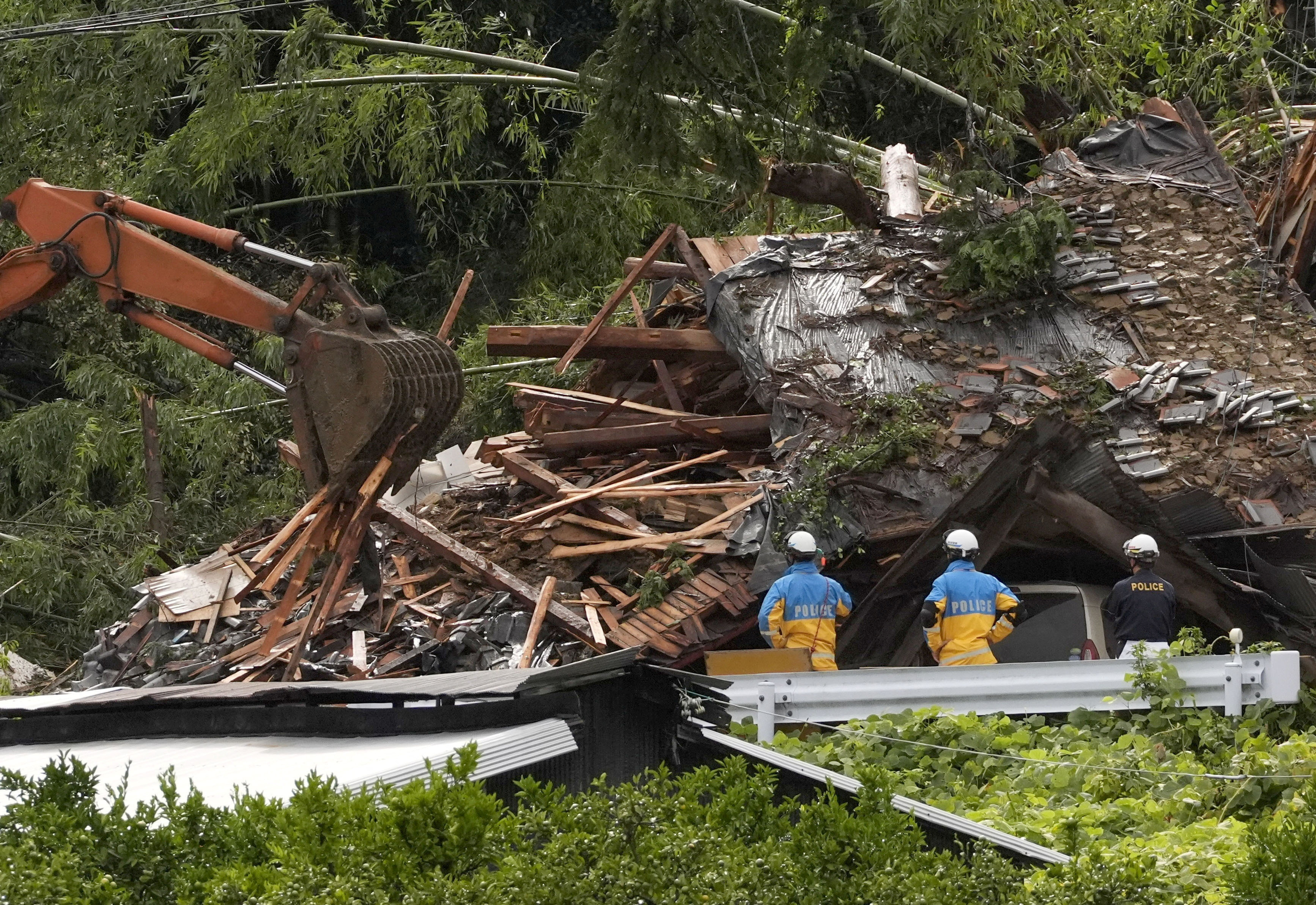 Police officers stand during a rescue operation at an area affected by landfall due to heavy rains caused by Typhoon Shanshan in Gamagori, Aichi prefecture