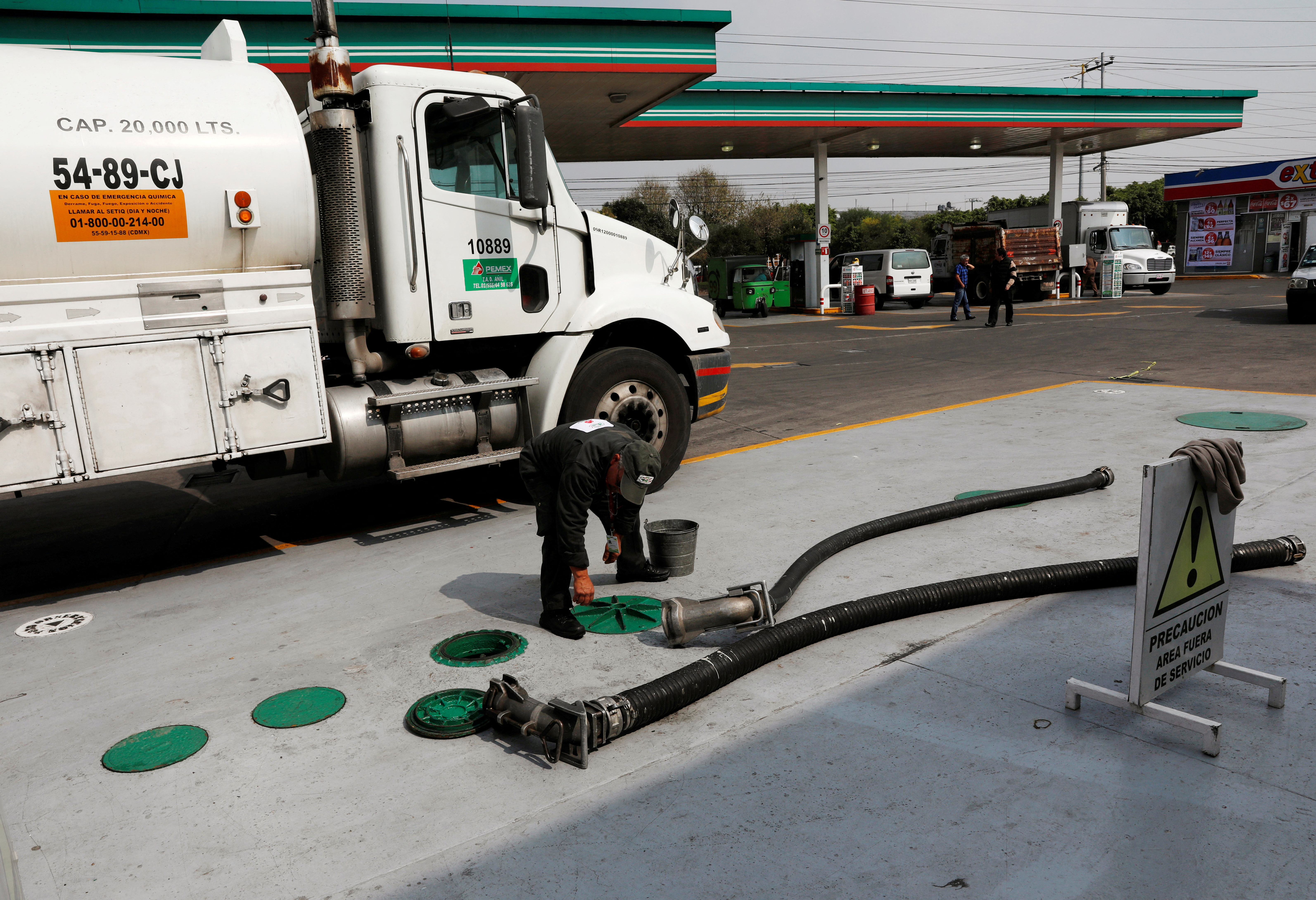 A tanker truck delivers fuel at a gas station in Mexico City