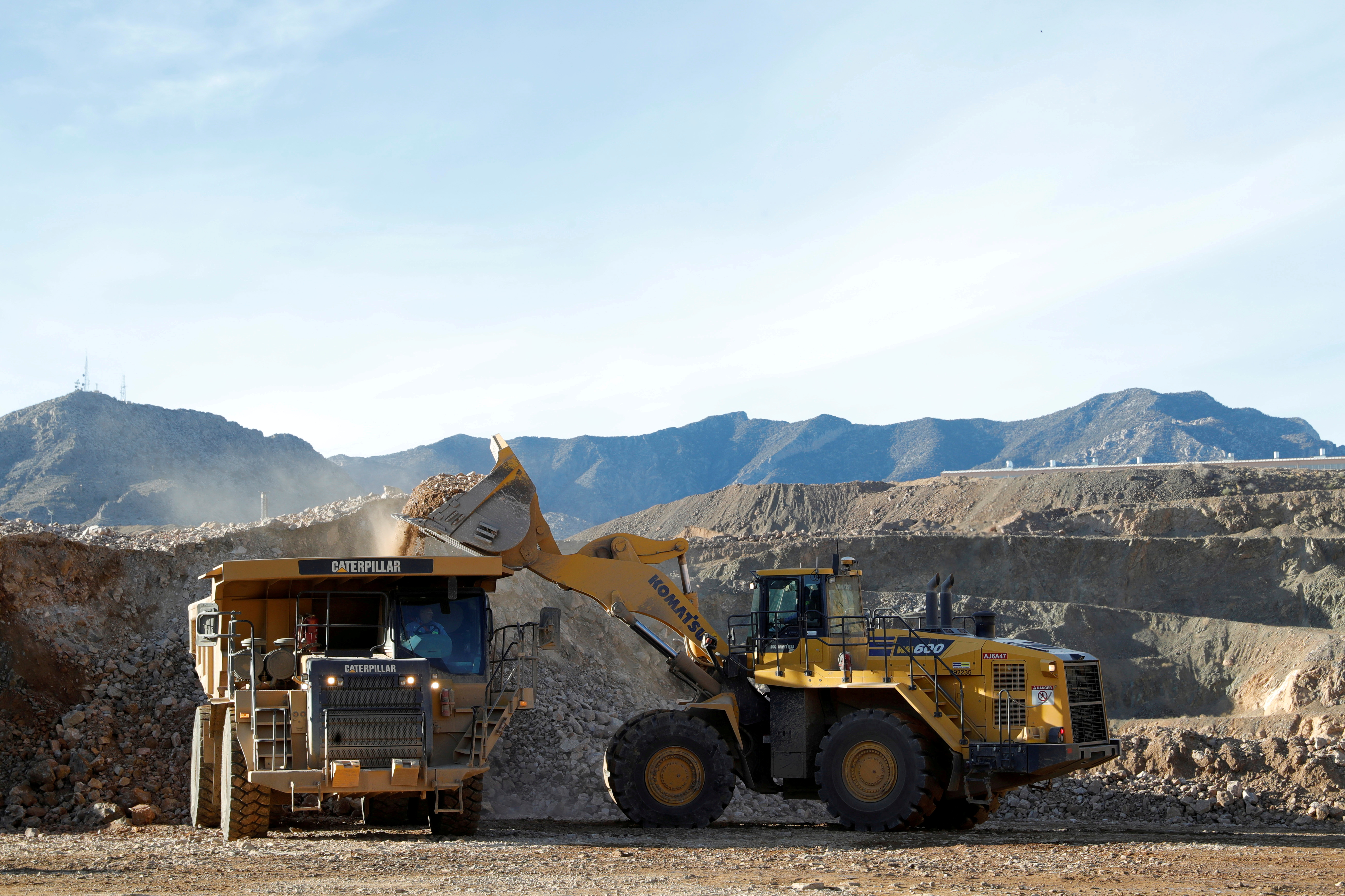 A wheel loader operator fills a truck with ore at the MP Materials rare earth mine in Mountain Pass