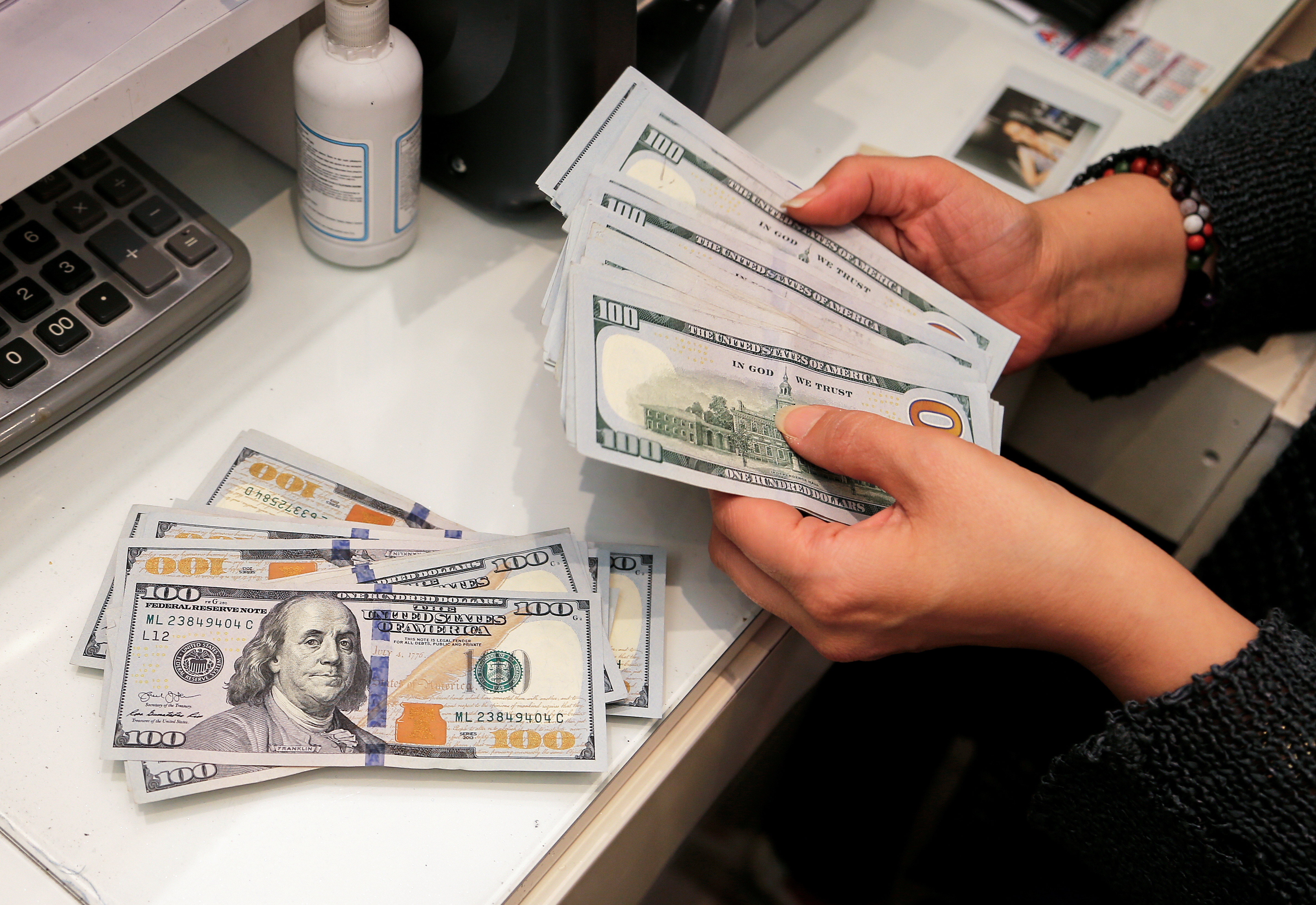 A money changer counting US dollar bills at an exchange office in Ankara