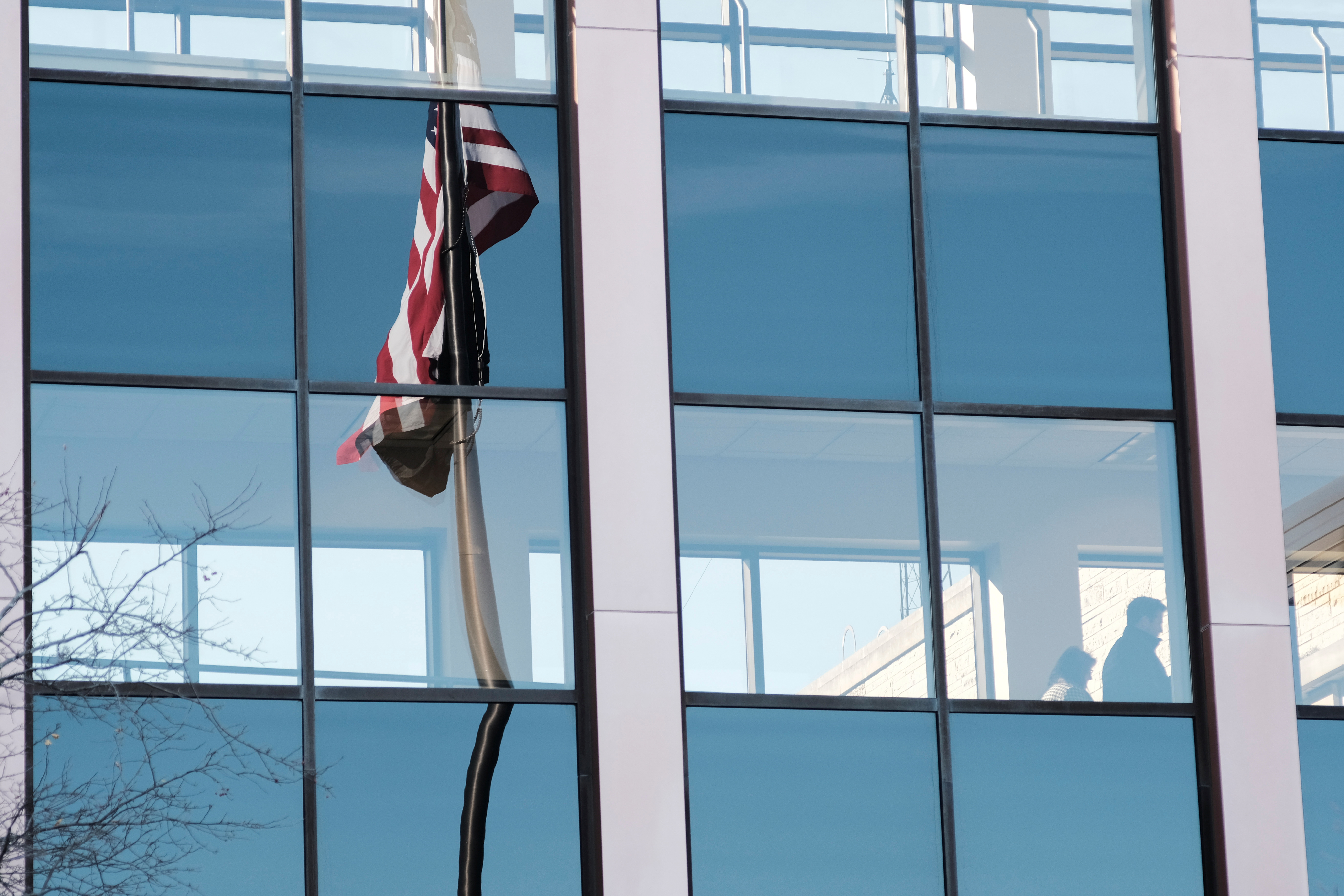A U.S. flag is reflected in the facade of the Waukesha County Courthouse where Darrell Brooks, accused of deliberately driving his car into a Christmas parade, is to appear today in Waukesha, Wisconsin, U.S., November 23, 2021.  REUTERS/Daniel Steinle   
