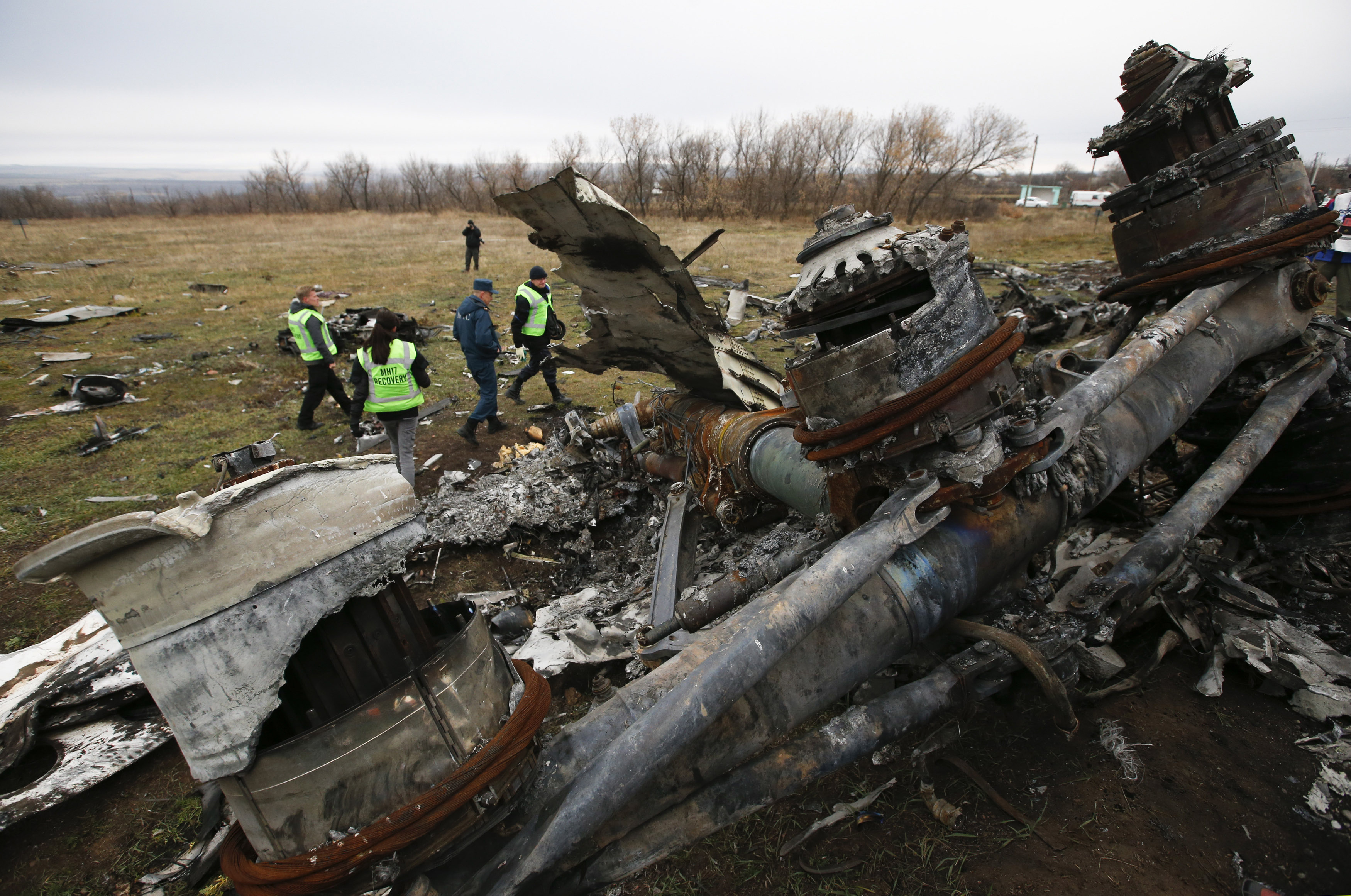 Dutch investigators and an Emergencies Ministry member work at the site where the downed Malaysia Airlines flight MH17 crashed, near the village of Hrabove in Donetsk region
