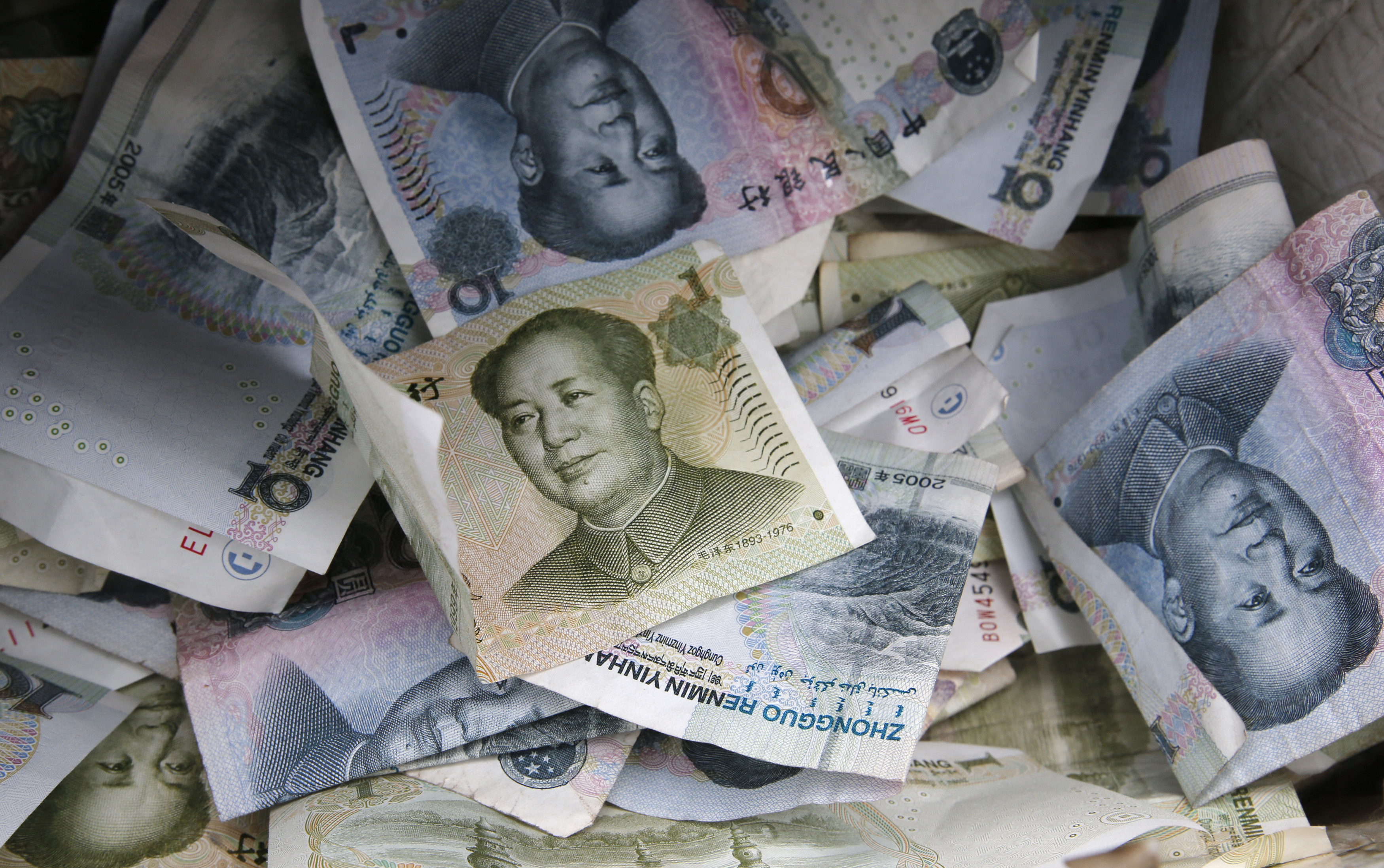 Chinese Yuan bank notes are seen at a vendor's cashbox at a market in Beijing