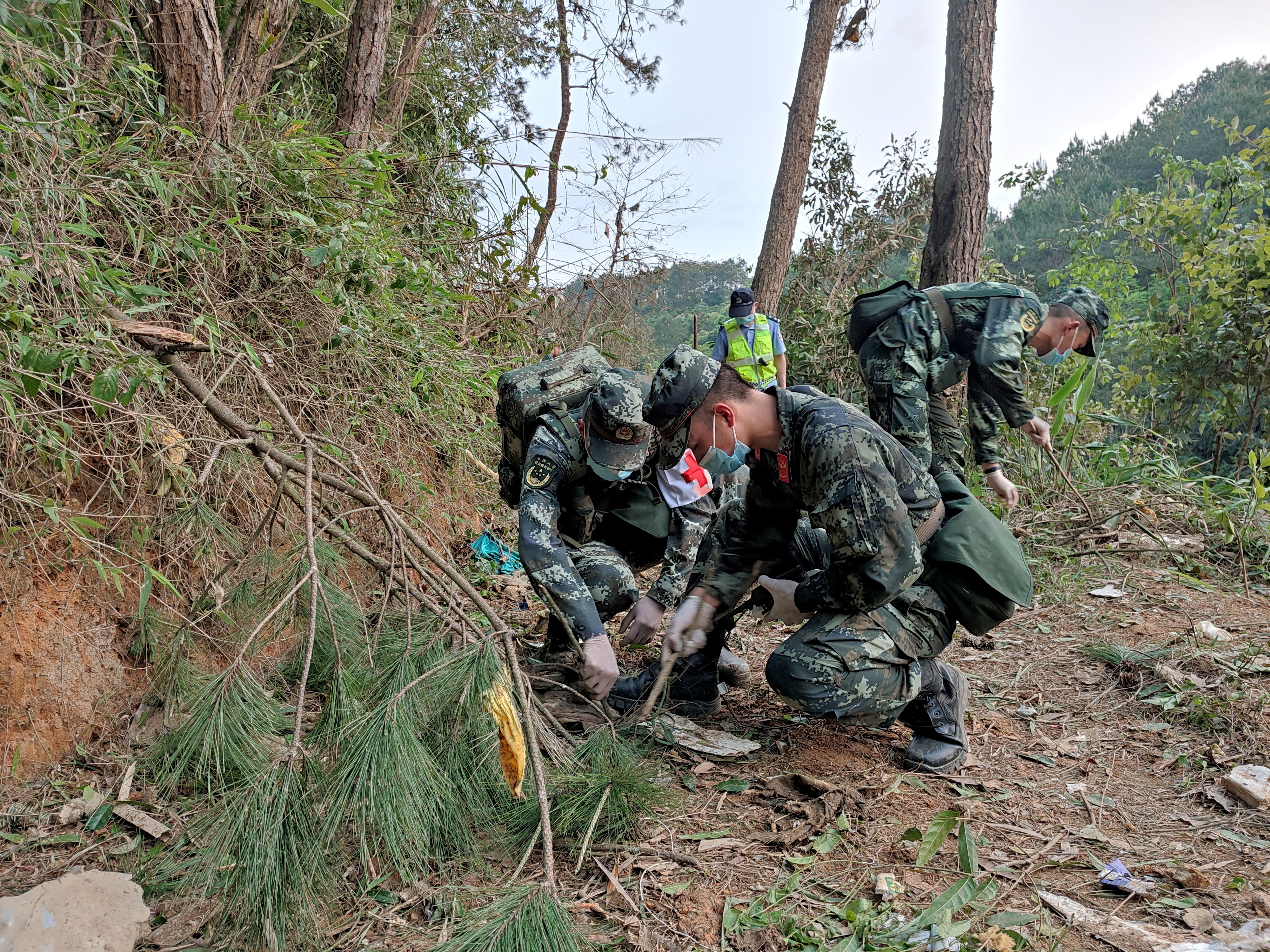 Paramilitary police officers work at the site where a China Eastern Airlines Boeing 737-800 plane crashed, in Wuzhou