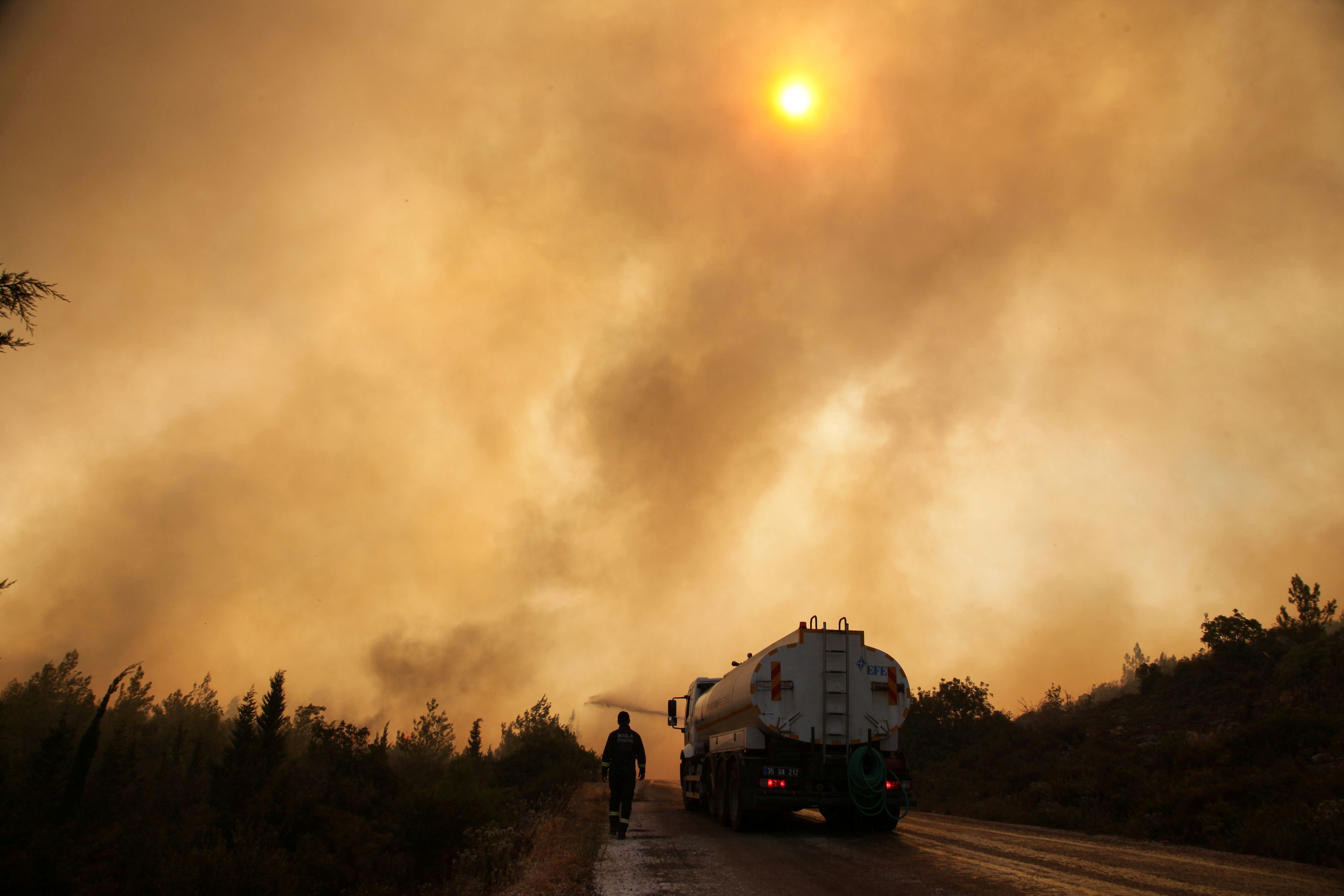 Firefighters extinguish a wildfire in the Mazi region near Bodrum, Turkey, August 2, 2021. REUTERS/Kenan Gurbuz  