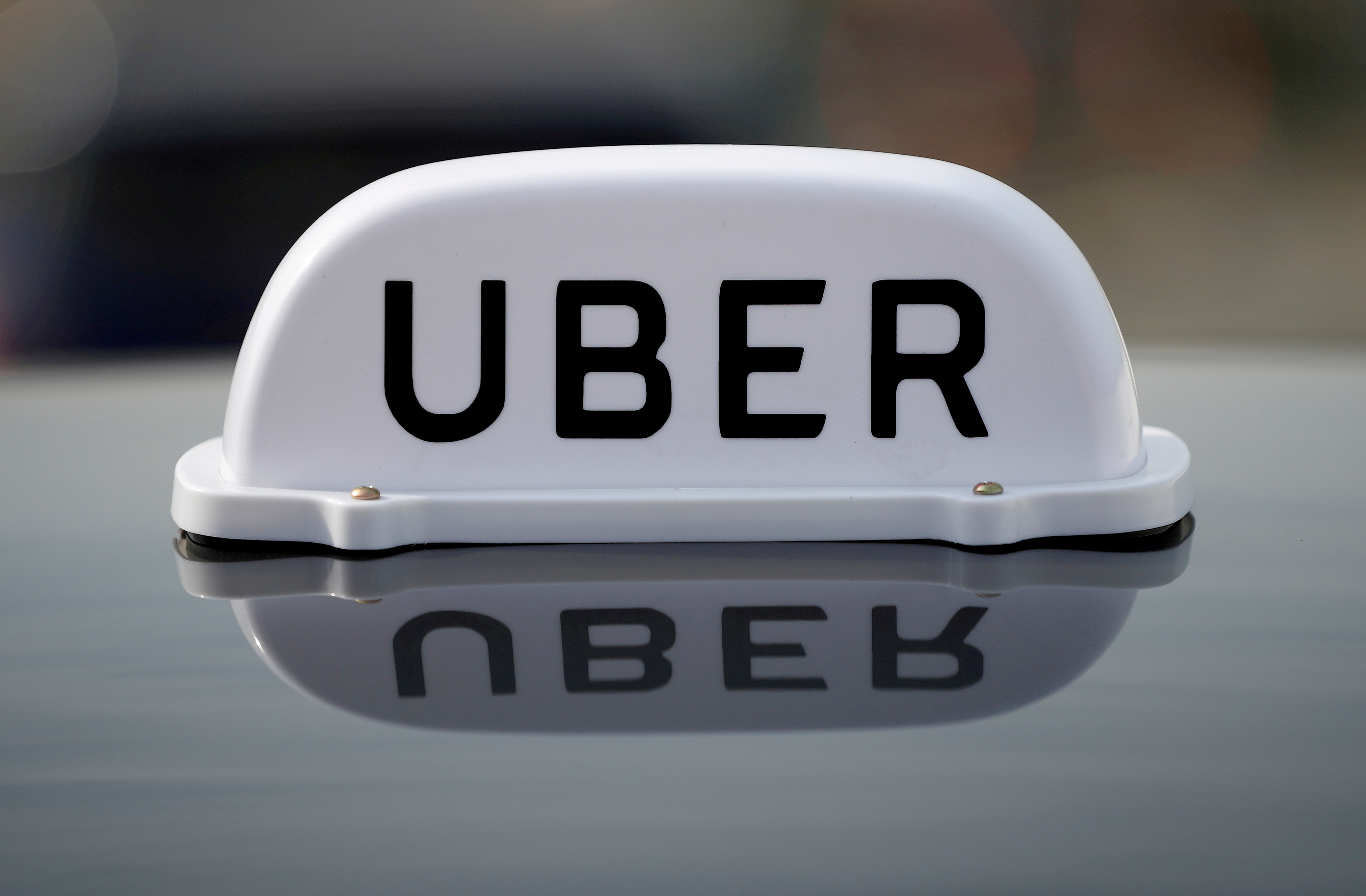 The Logo of taxi company Uber is seen on the roof of a private hire taxi in Liverpool
