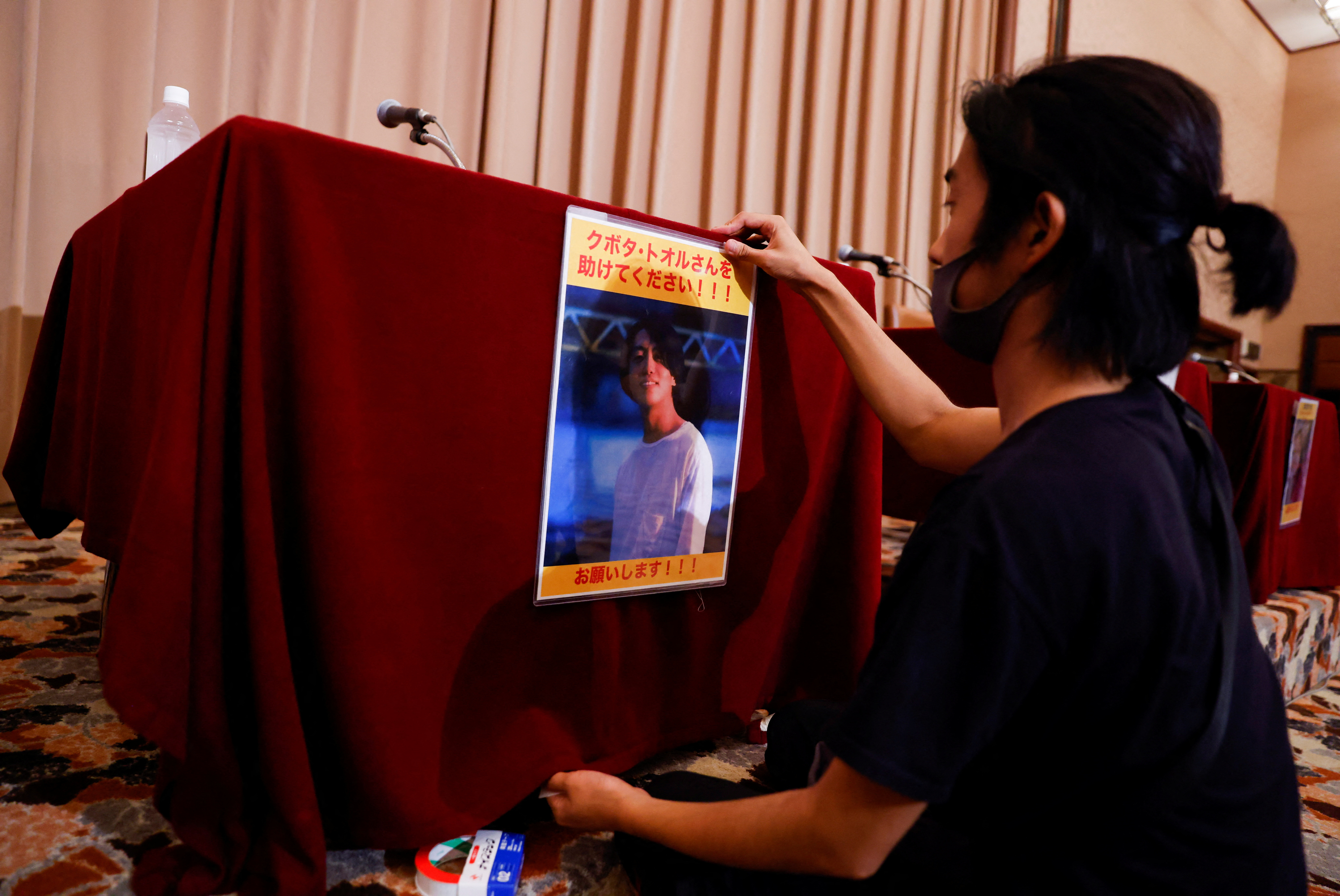 A portrait photo of Japanese documentary filmmaker Toru Kubota, who has been detained in Myanmar, is displayed during a news conference in Tokyo