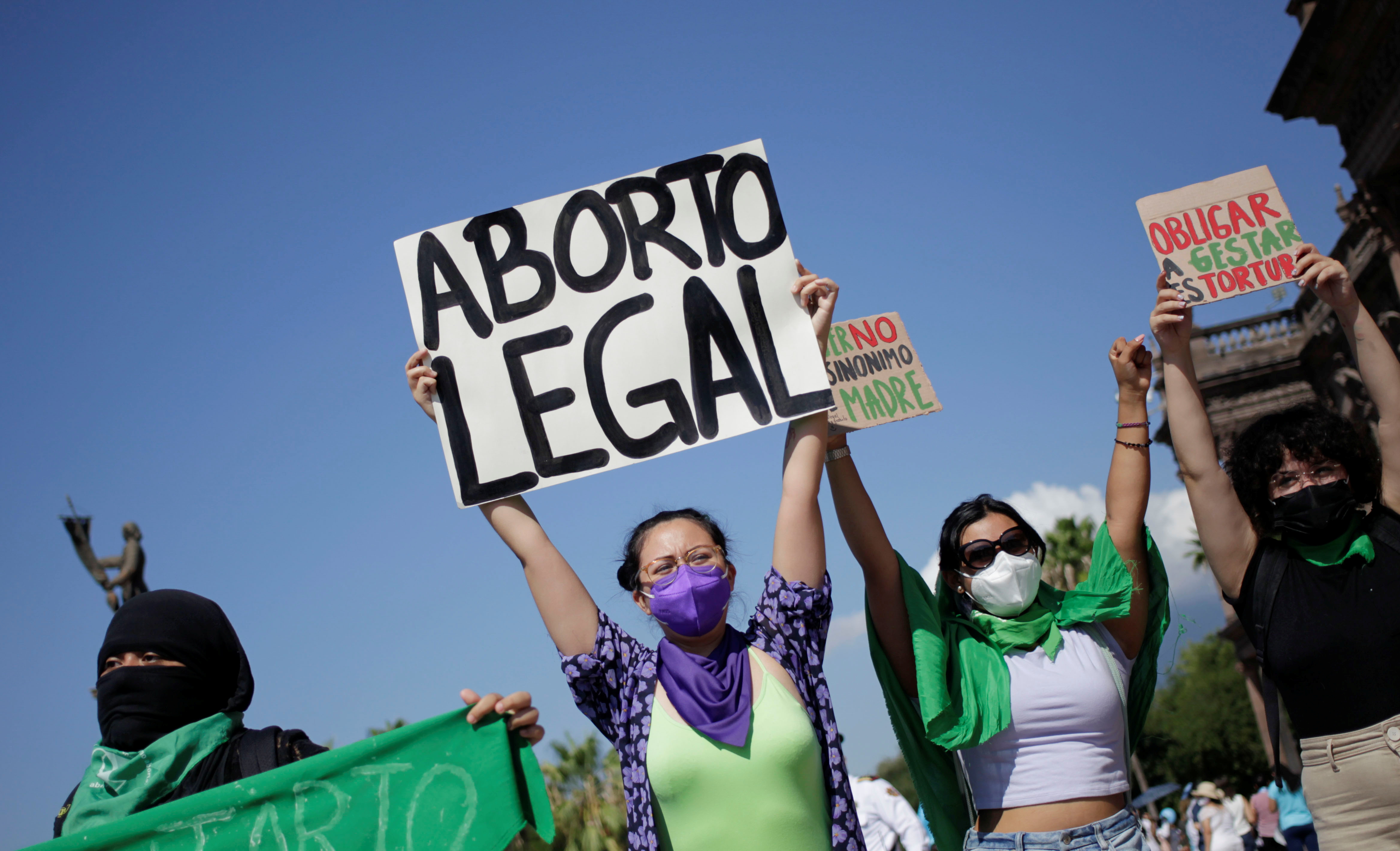 Pro-abortion activists hold up banners during a protest against abortion, in Monterrey