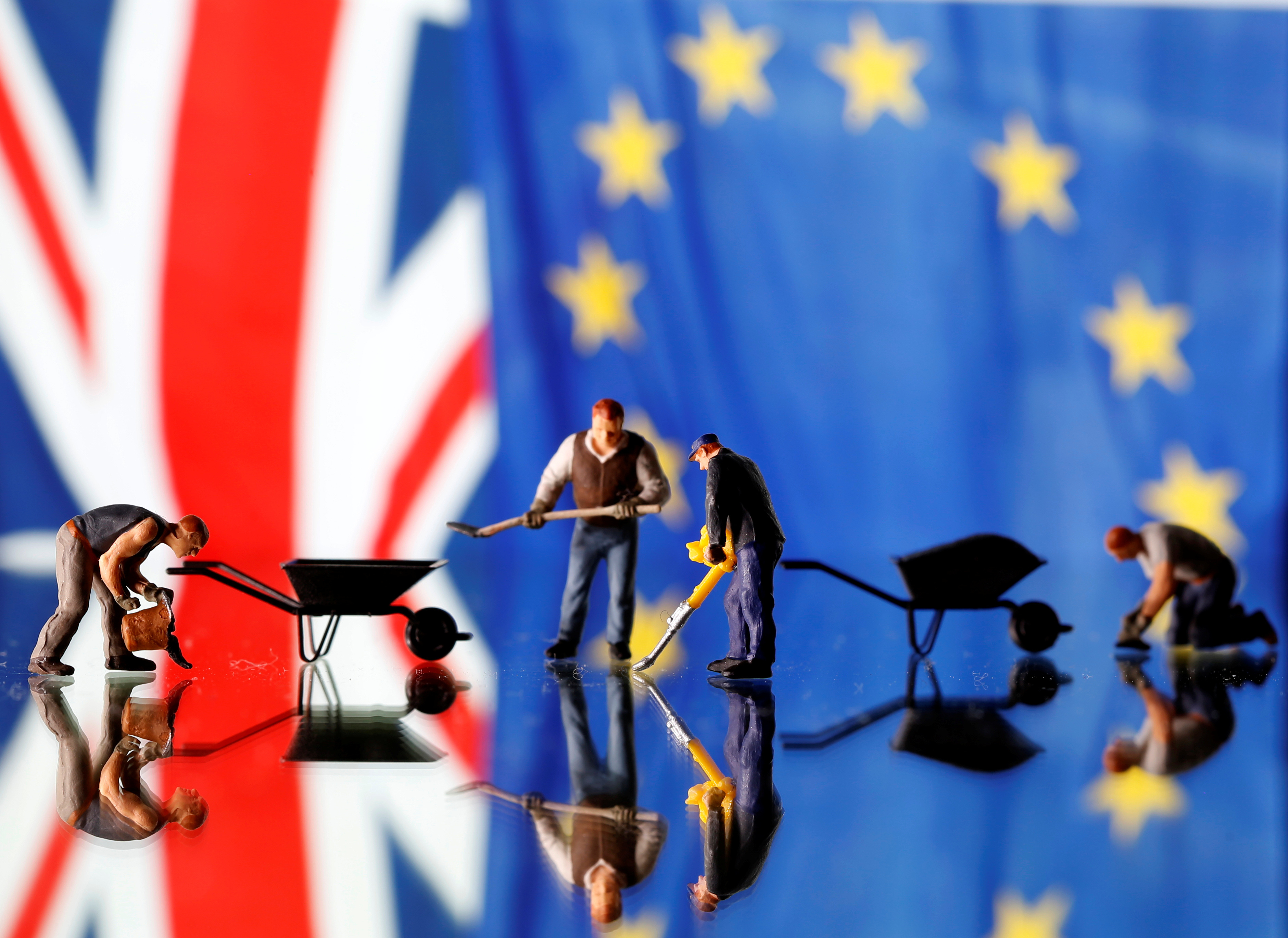 Small toy figures are seen in front of UK and European Union displayed flags in this illustration picture,