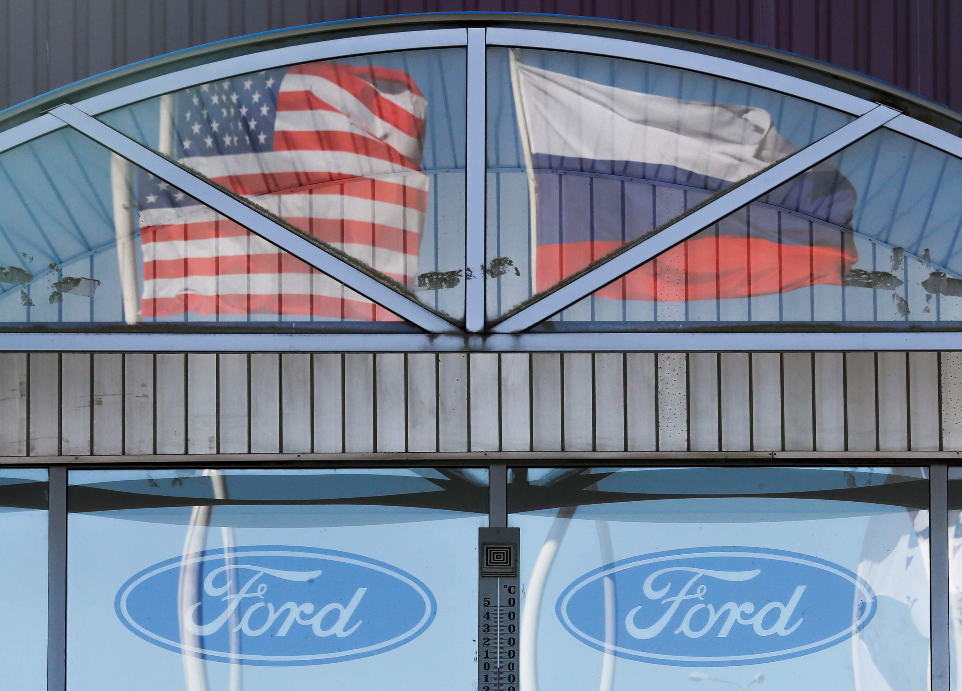 Russian and U.S. state flags are reflected in windows of a factory of Ford Sollers, a joint venture of U.S. carmaker Ford with Russian partners, in Vsevolozhsk