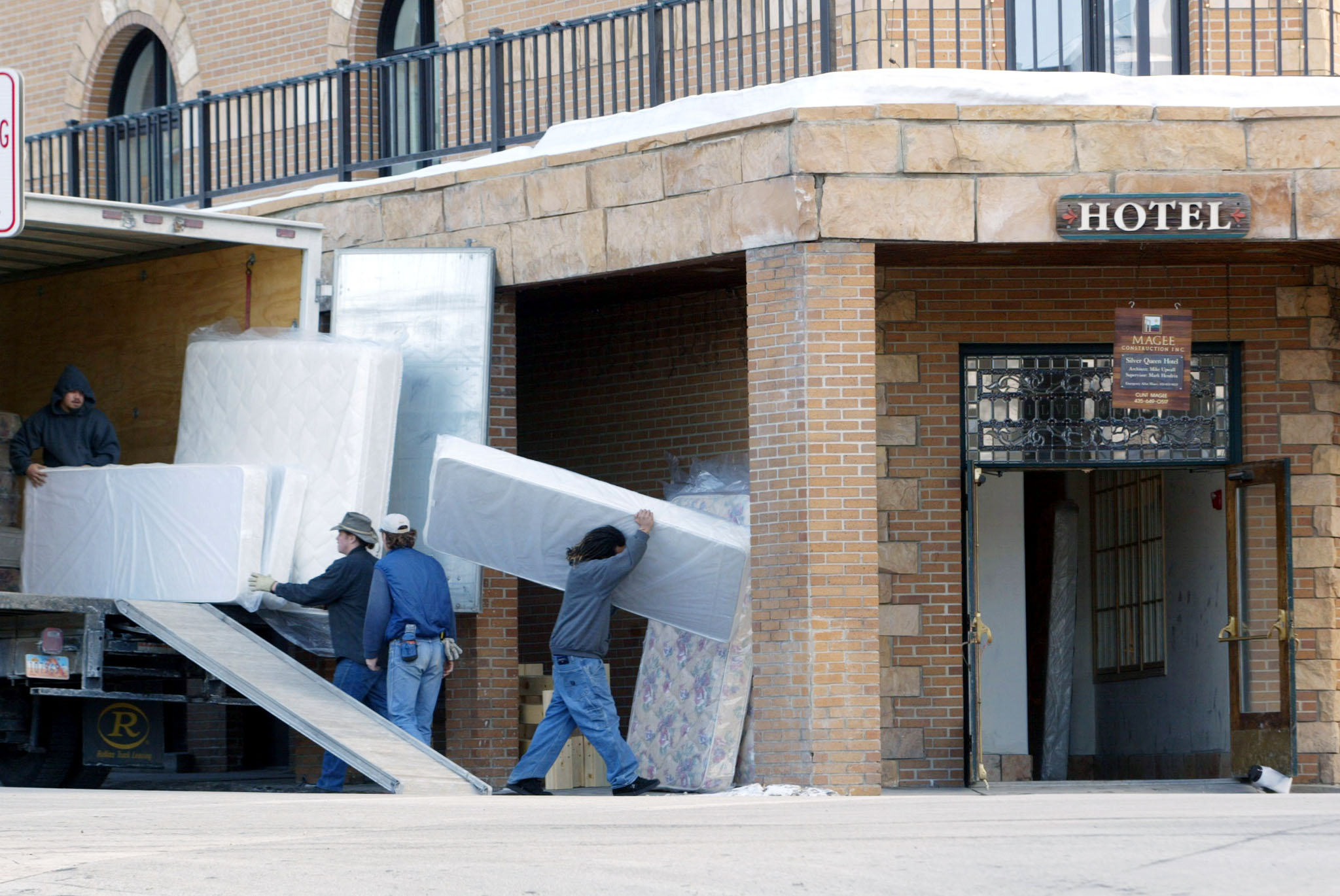 Workers carry mattresses into a hotel in downtown Park City