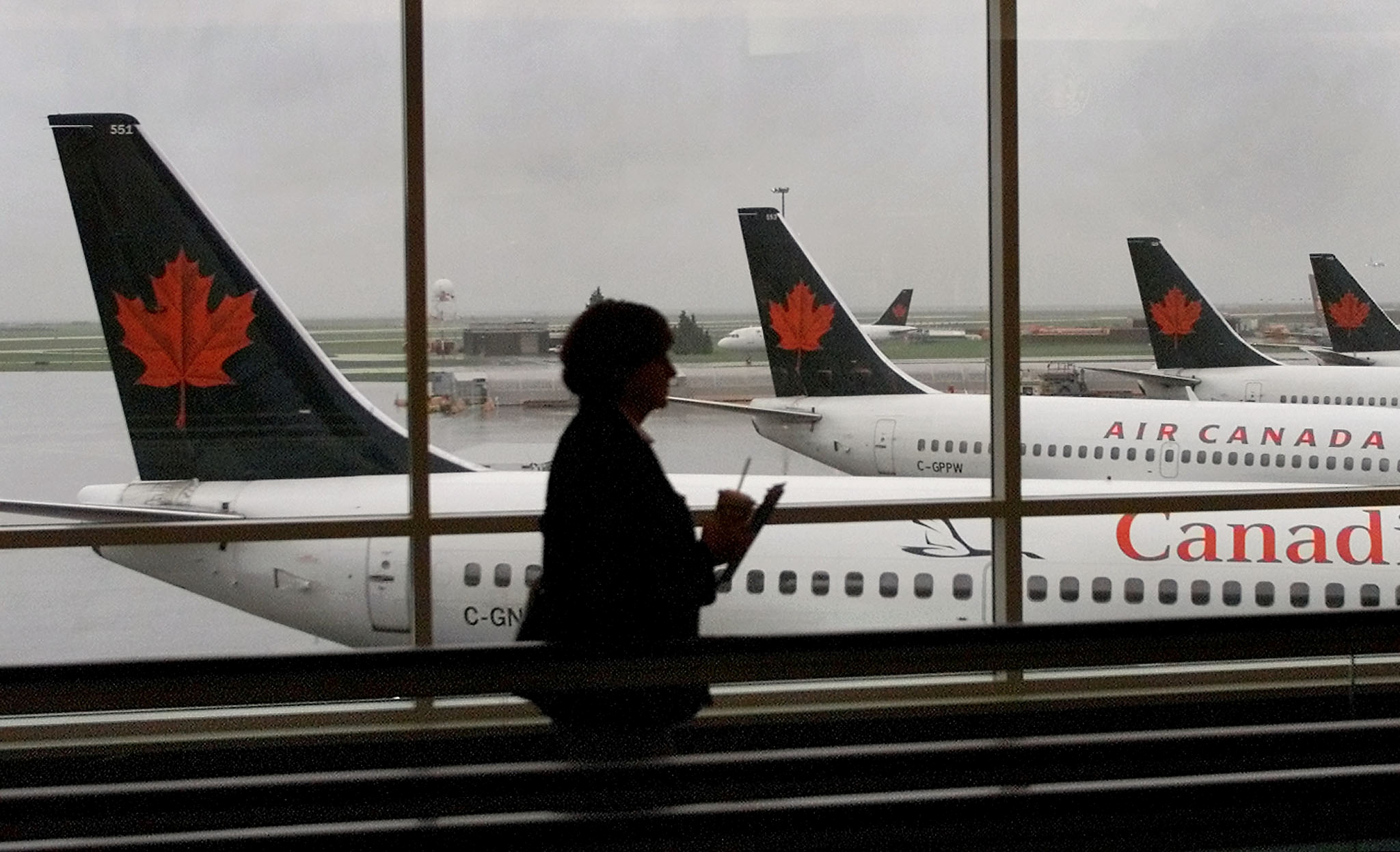 A passenger walks past several Air Canada jets at Vancouver International Airport
