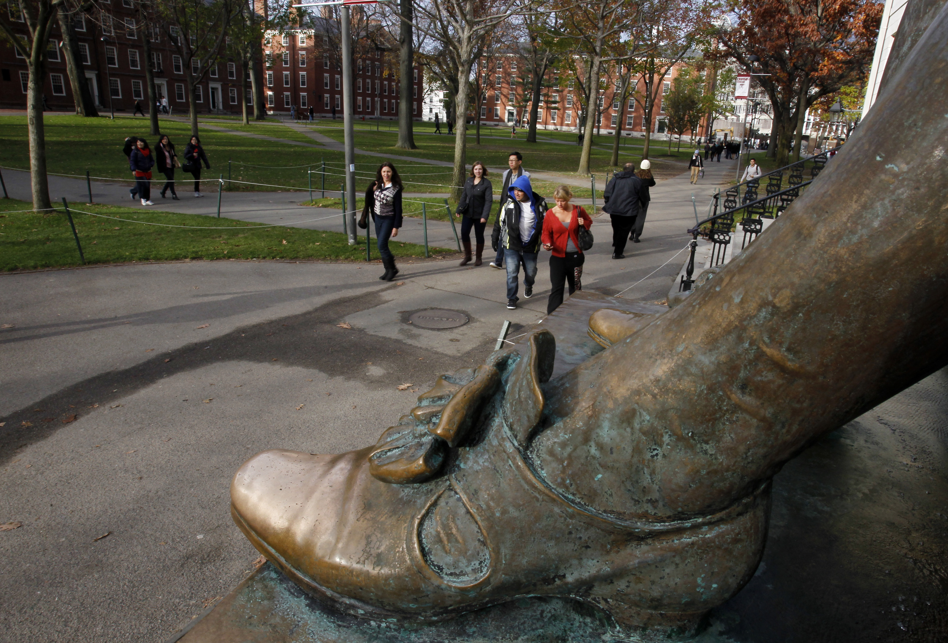 The shiny toe of the John Harvard Statue is seen in Harvard Yard at Harvard University in Cambridge