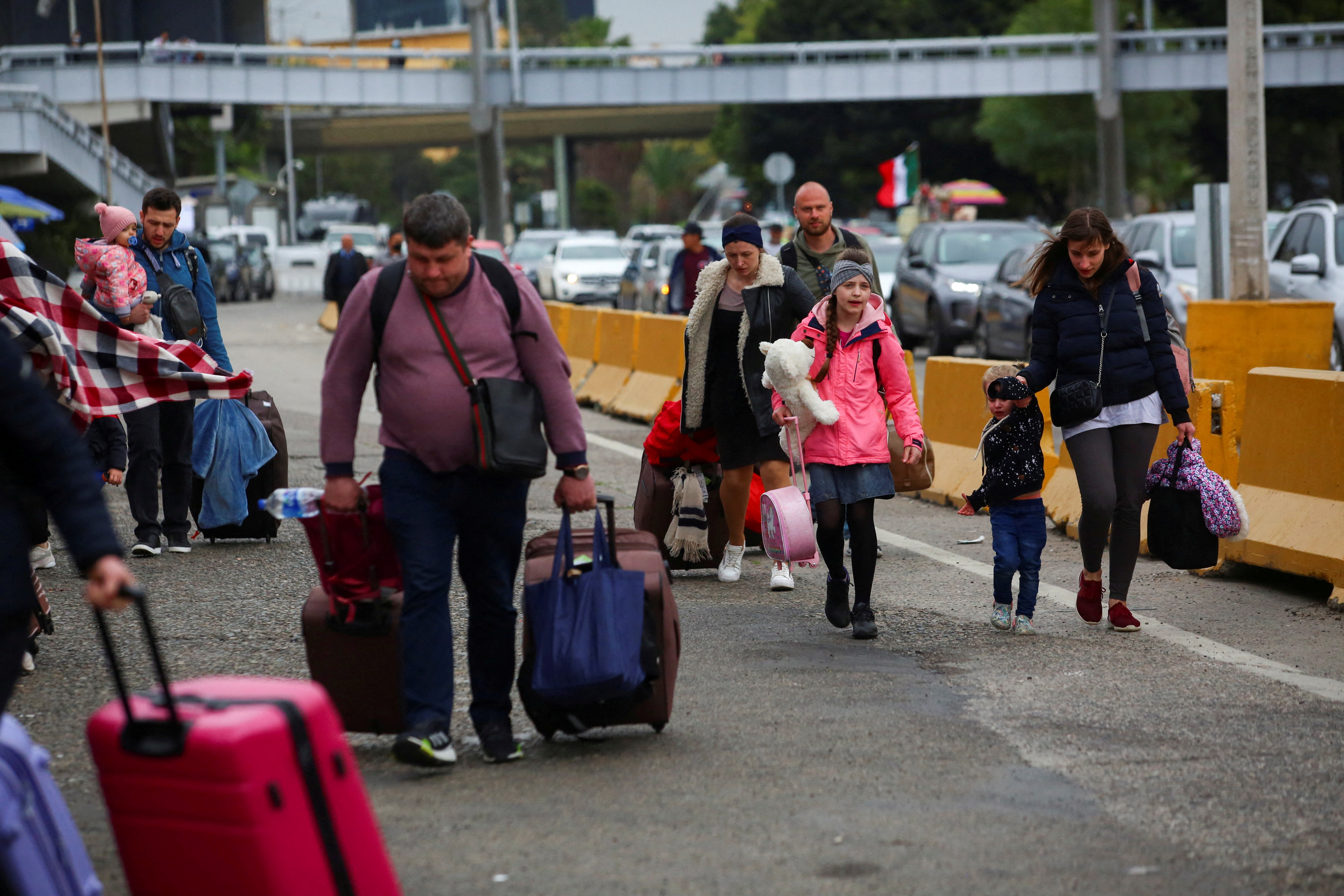 Ukrainians who fled to Mexico amid Russia's invasion of their homeland, walk with their belongings to cross the San Ysidro Land Port of Entry of the U.S.-Mexico border, in Tijuana