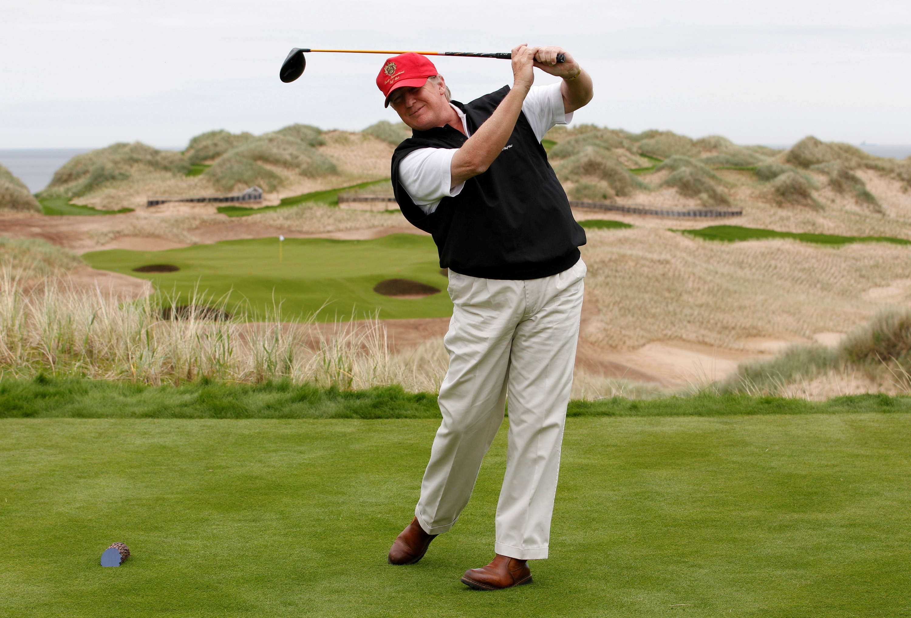 U.S. property magnate Donald Trump practices his swing at the 13th tee of his new Trump International Golf Links course near Aberdeen