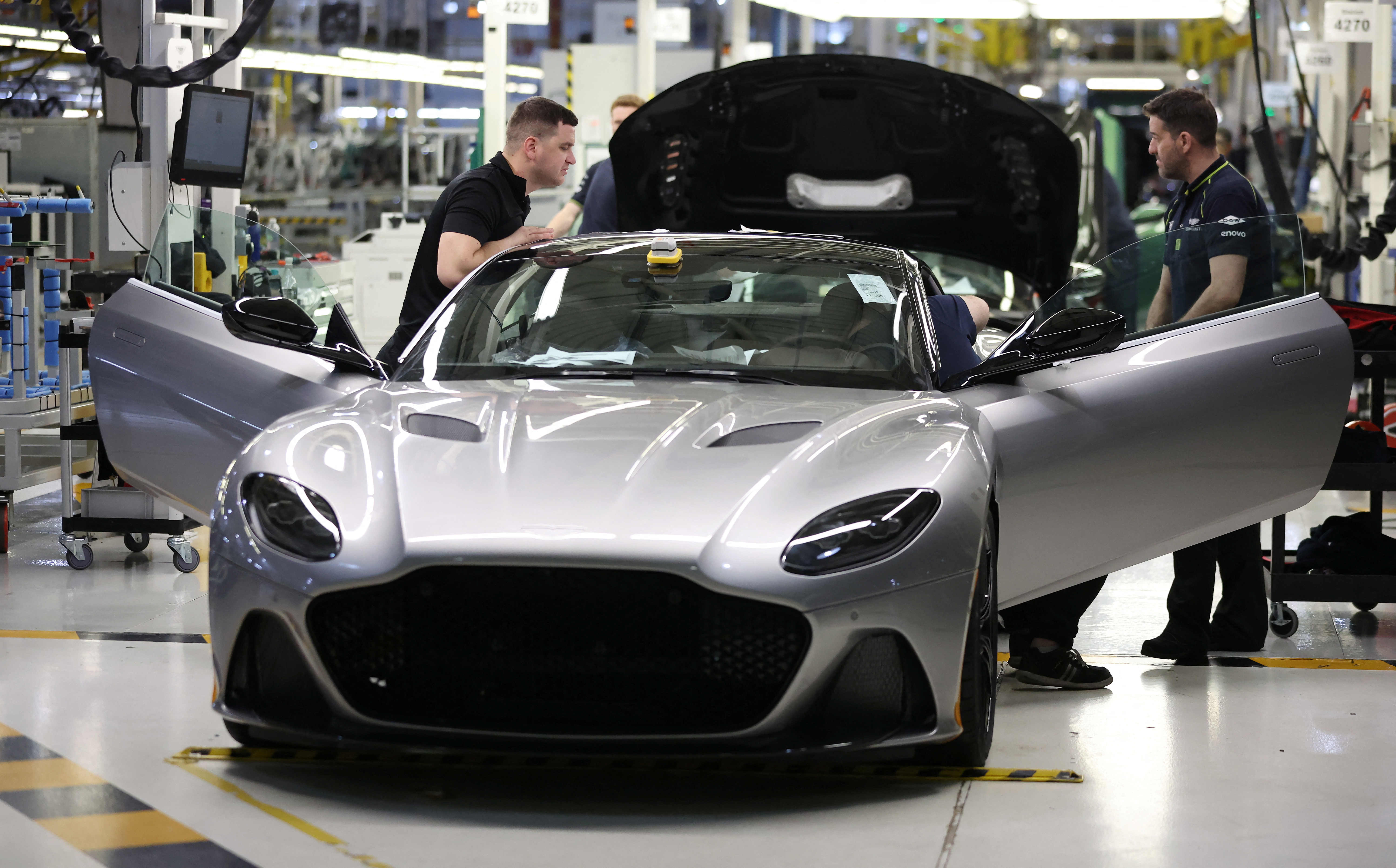 Employees work on a car at the Aston Martin factory in Gaydon
