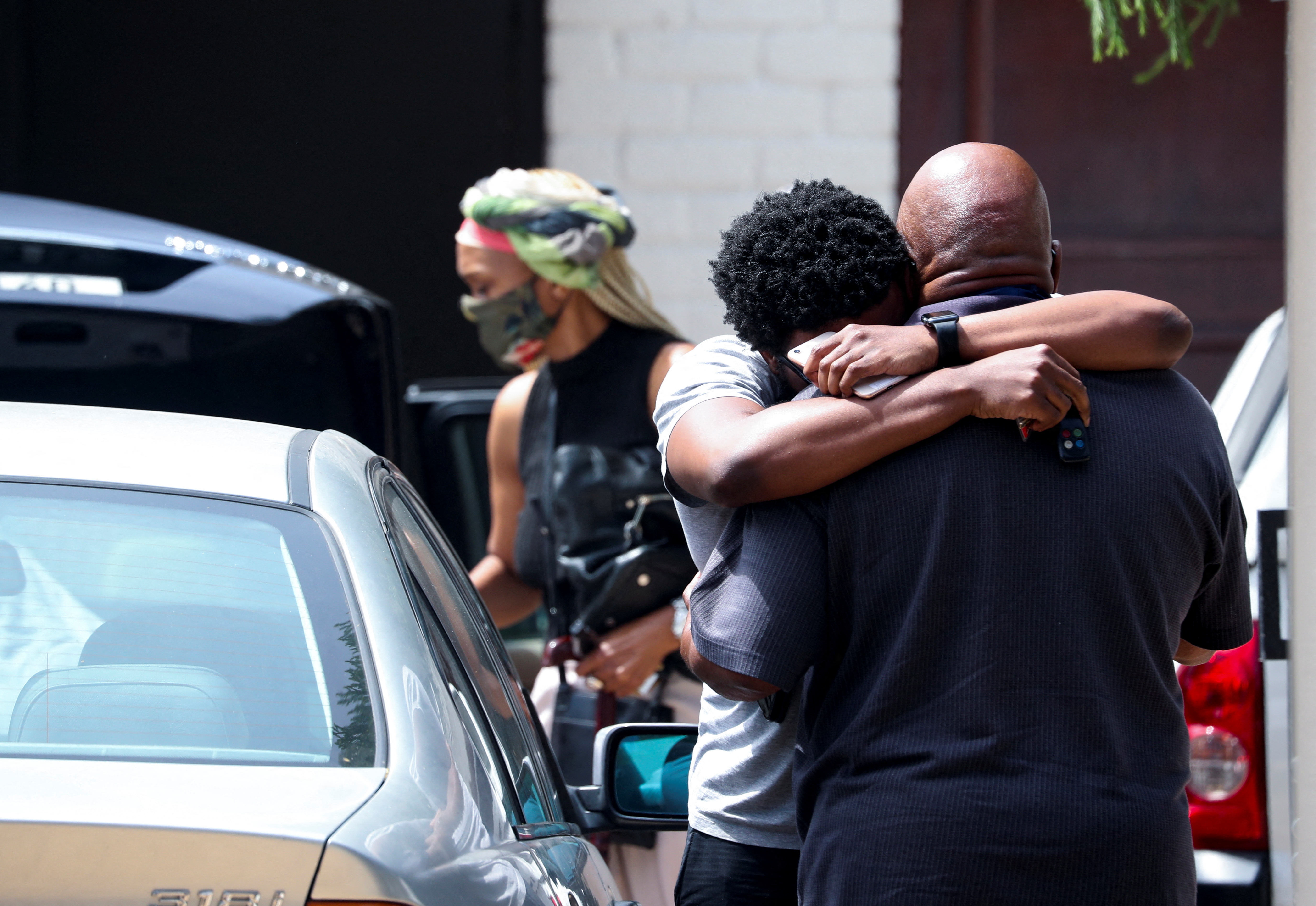 Friends and relatives of Archbishop Desmond Tutu console each other outside his home in Cape Town