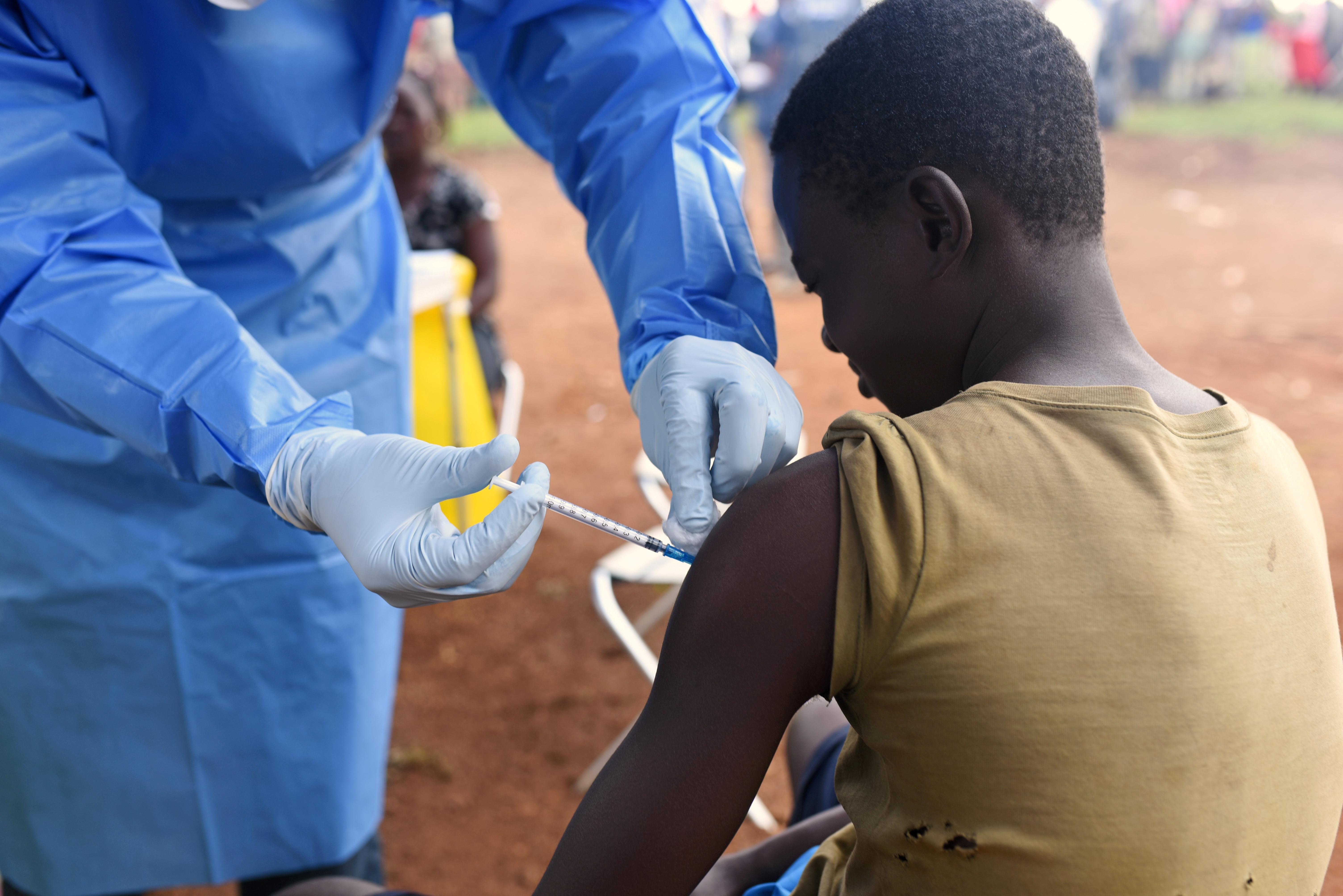 A Congolese health worker administers Ebola vaccine to a boy who had contact with an Ebola sufferer in the village of Mangina