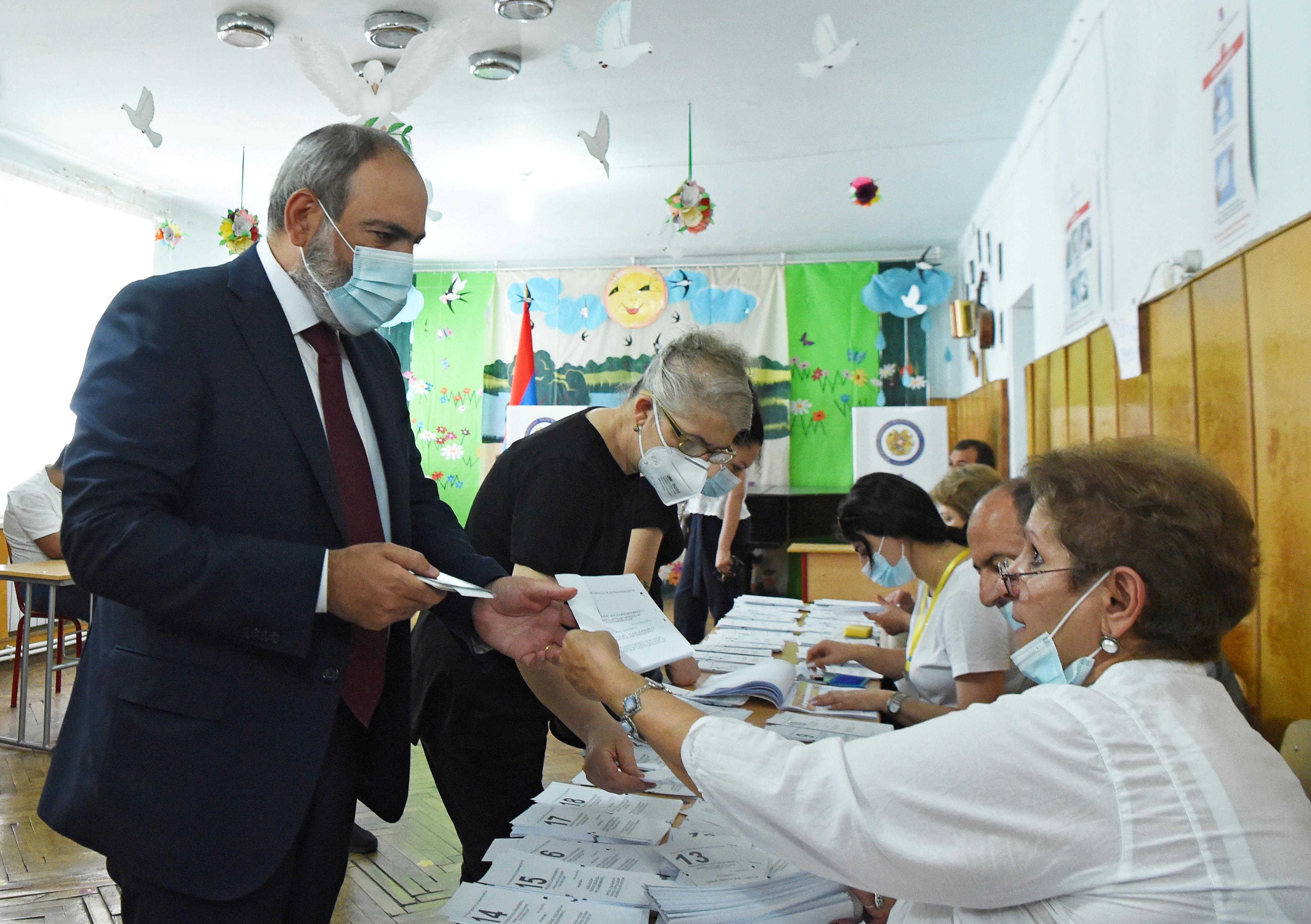 Armenia's acting Prime Minister and leader of Civil Contract party Nikol Pashinyan receives a ballot at a polling station during the snap parliamentary election in Yerevan, Armenia June 20, 2021. Lusi Sargsyan/Photolure via REUTERS