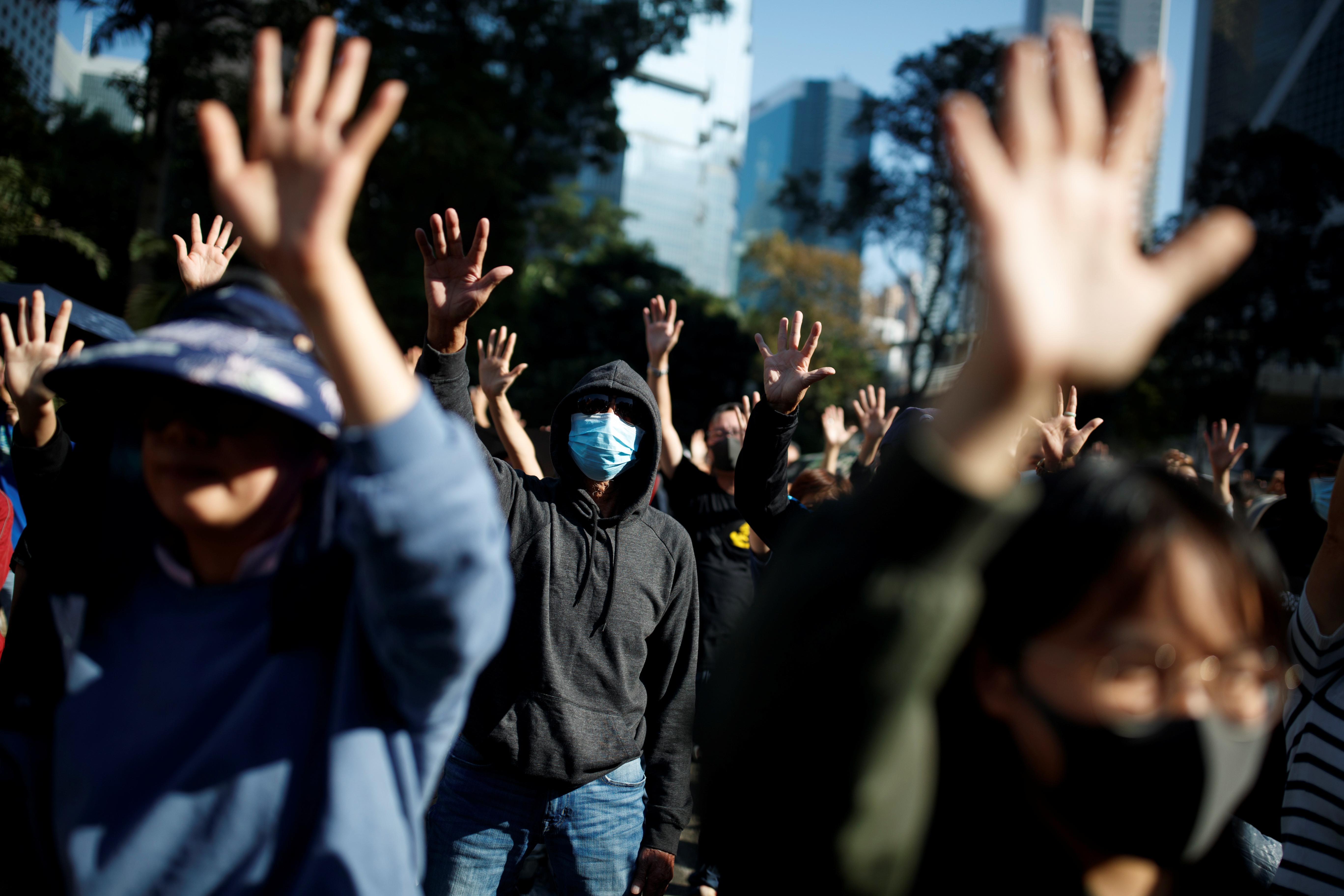 People raise their hands as they sing the protest anthem 