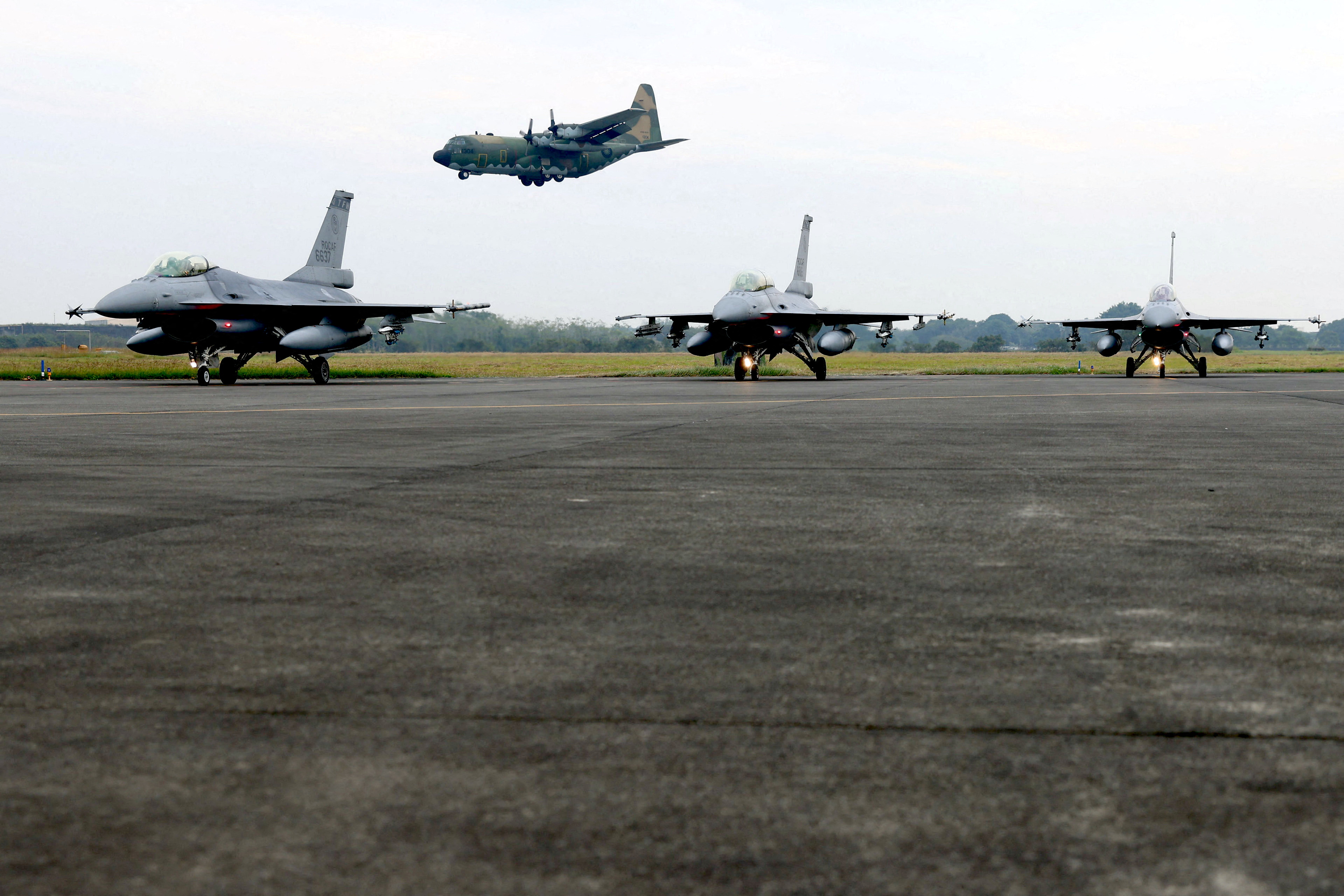 A Taiwan C-130 flies past two F-16V fighter jets during an annual New Year's drill in Chiayi