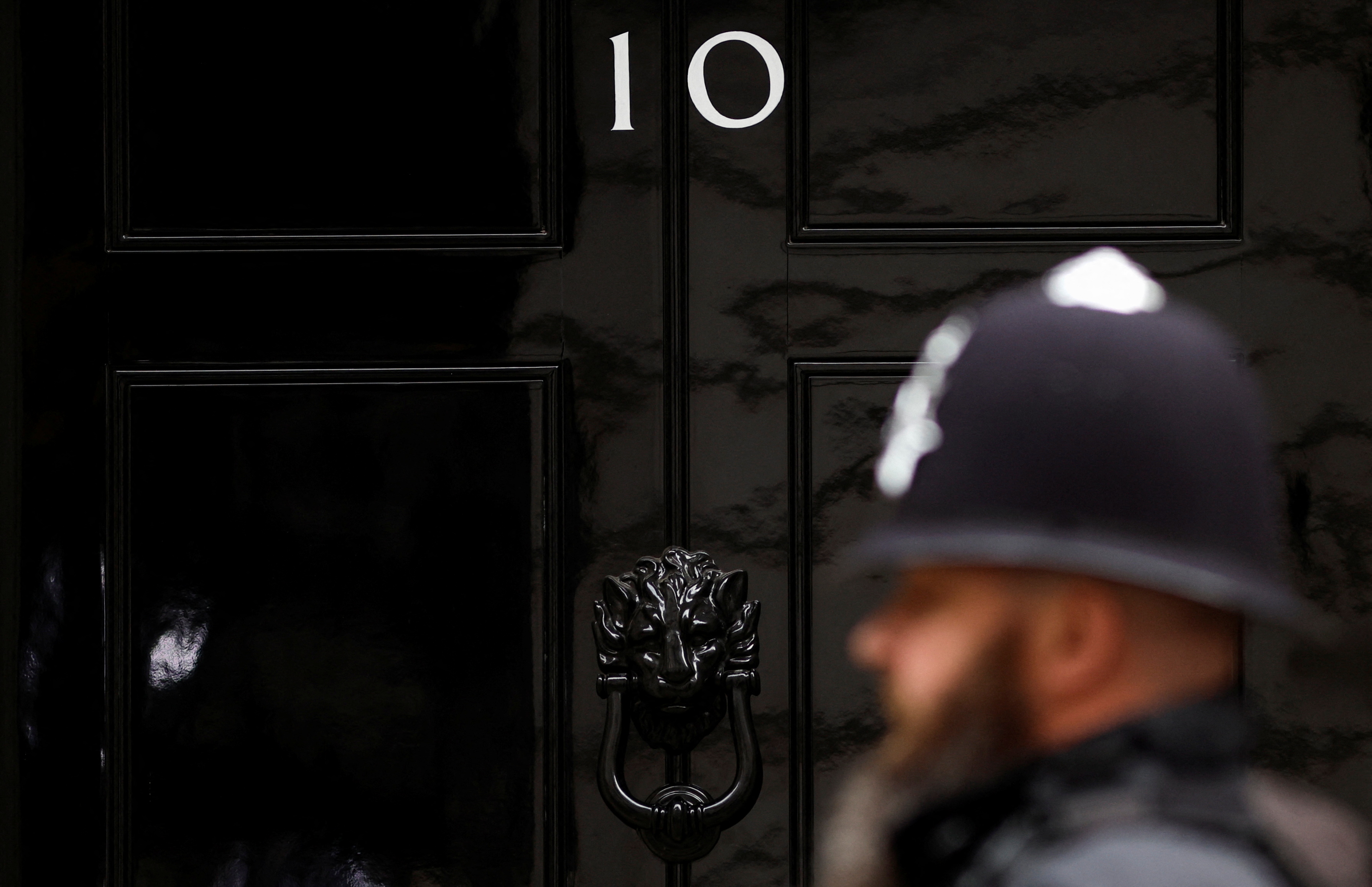 A police officer walks past the door of No. 10 Downing Street in London