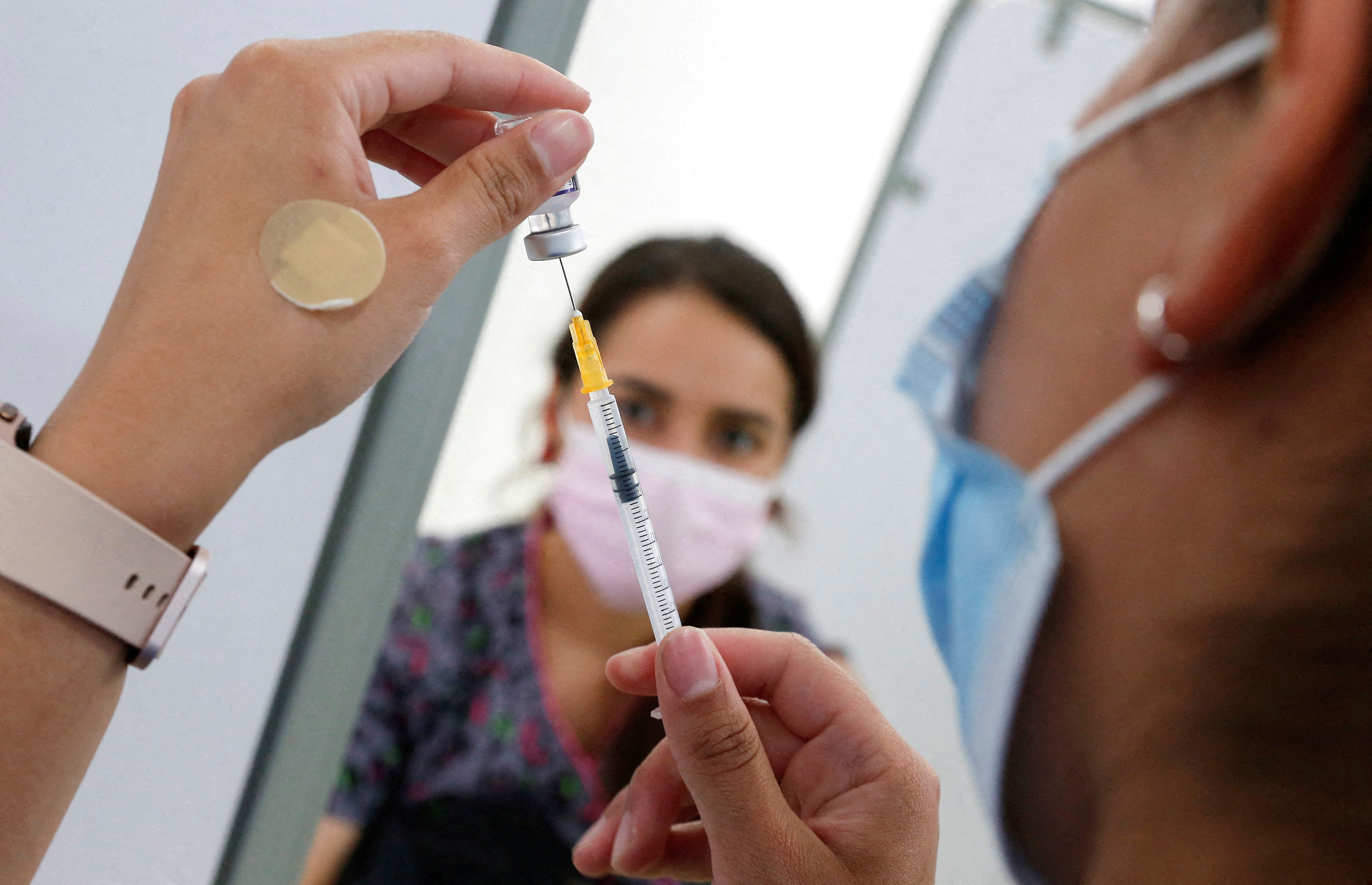 A healthcare worker prepares a vaccine against the coronavirus disease (COVID-19) at a mobile vaccine clinic, in Valparaiso, Chile, January 3, 2022. REUTERS/Rodrigo Garrido