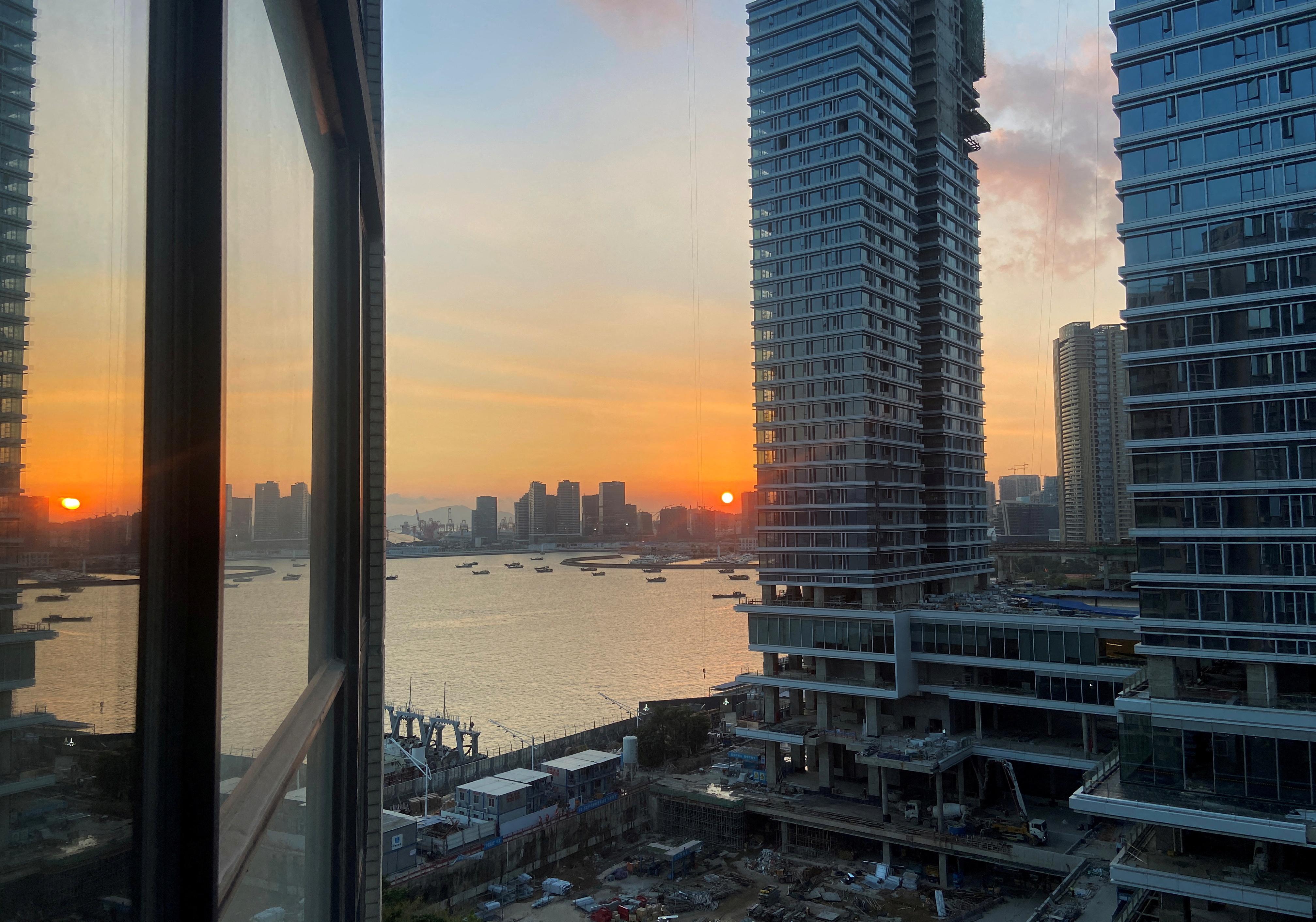 Under-construction apartments are pictured from a building during sunset in the Shekou area of Shenzhen, Guangdong