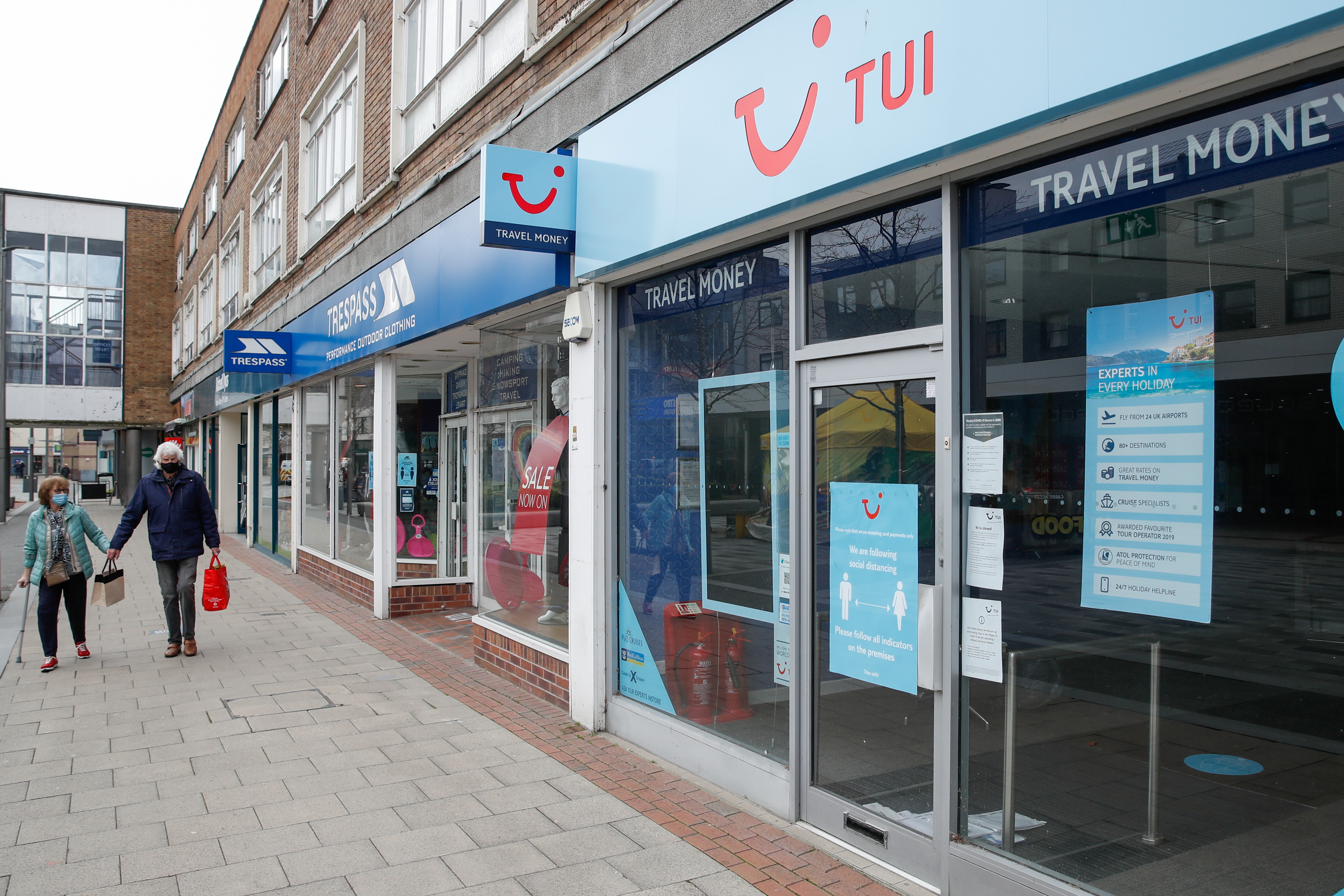Two people walk past the TUI travel centre, amid the coronavirus disease (COVID-19) outbreak, in Hemel Hempstead, Britain, March 24, 2021. REUTERS/Paul Childs