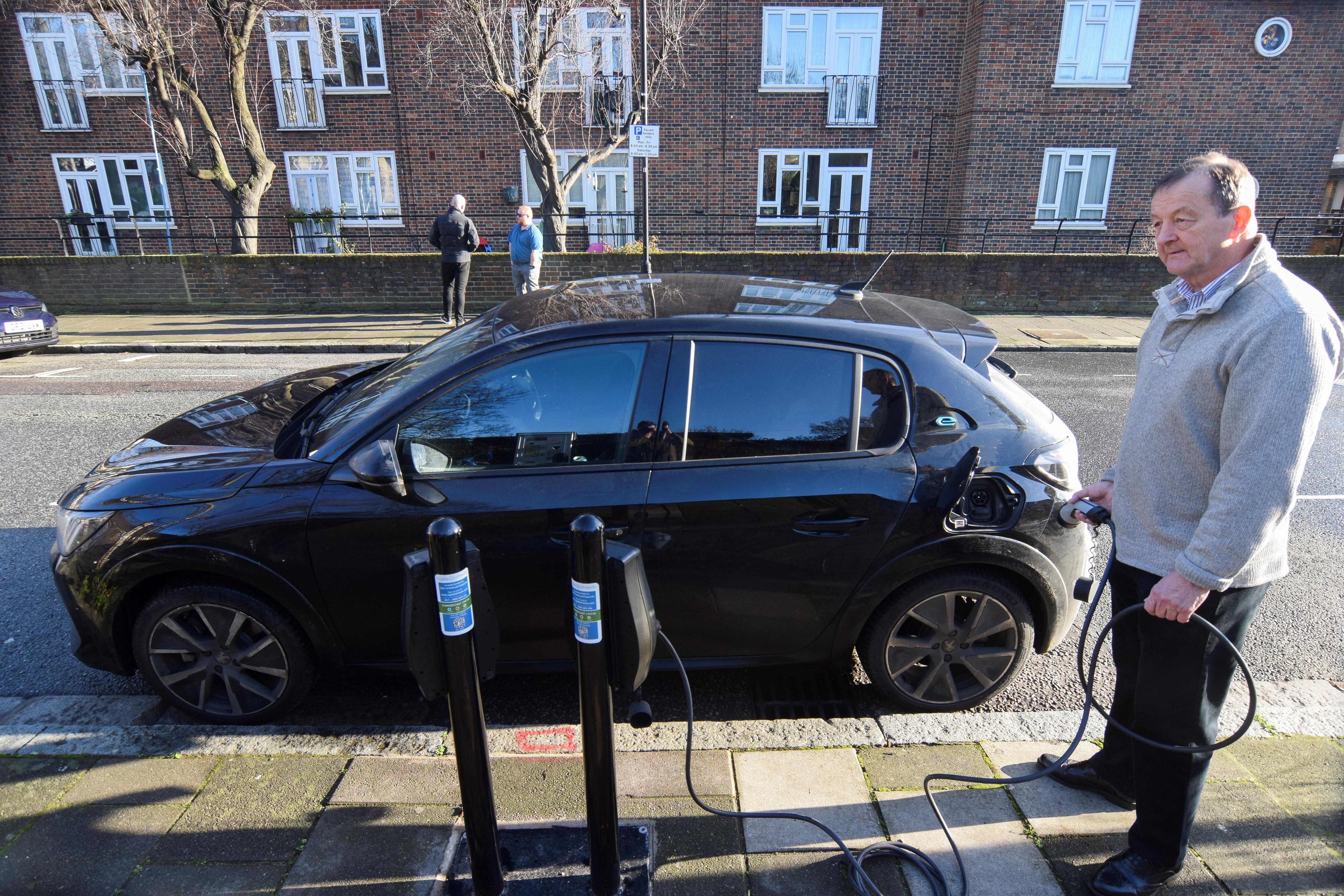 Connected Kerb customer Ged O'Sullivan plugs an electric vehicle into one of the charging infrastructure company's smart public on-street chargers in the borough of Hackney, London