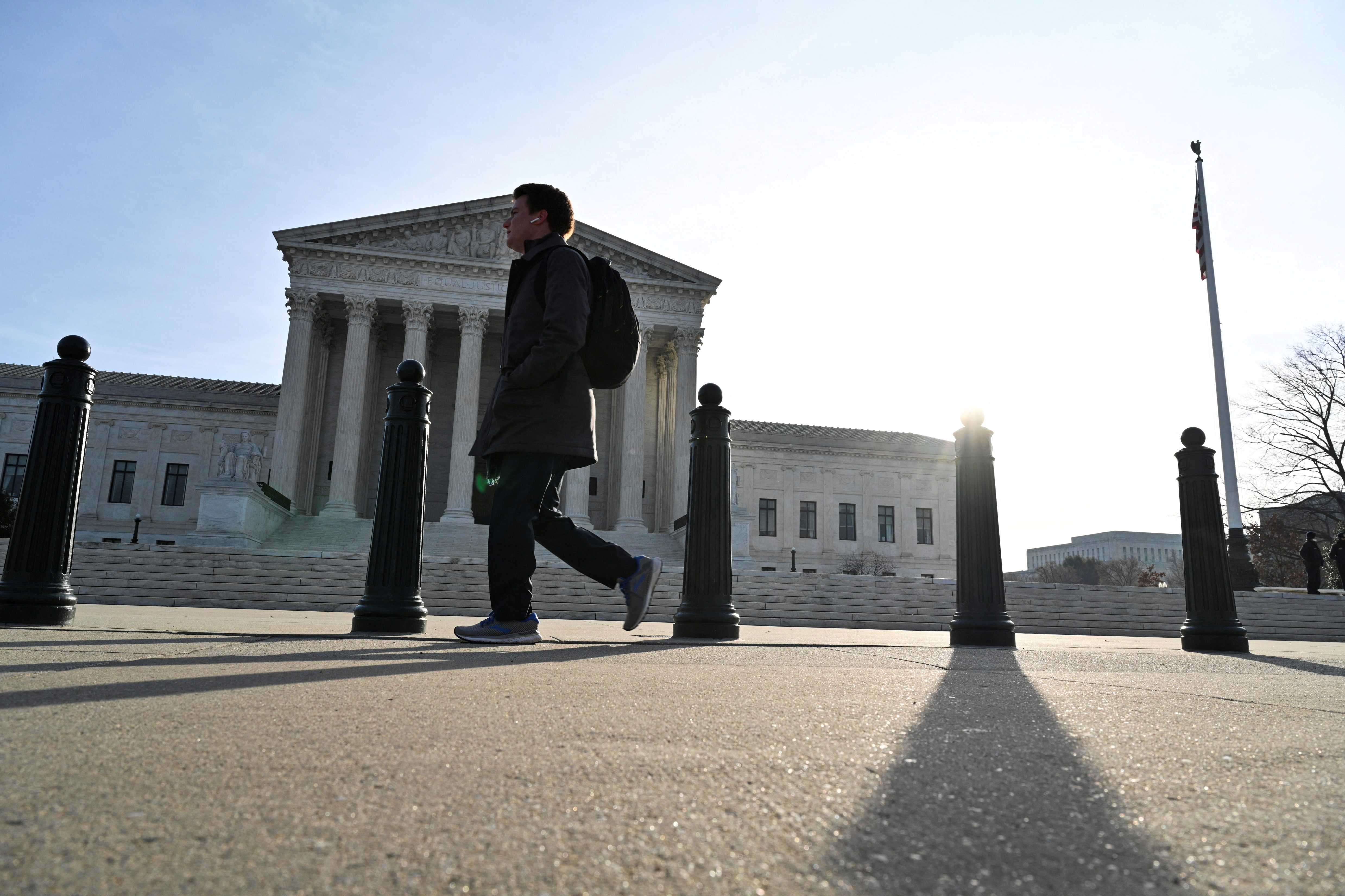 Person walks down the sidewalk near the U.S. Supreme Court building in Washington