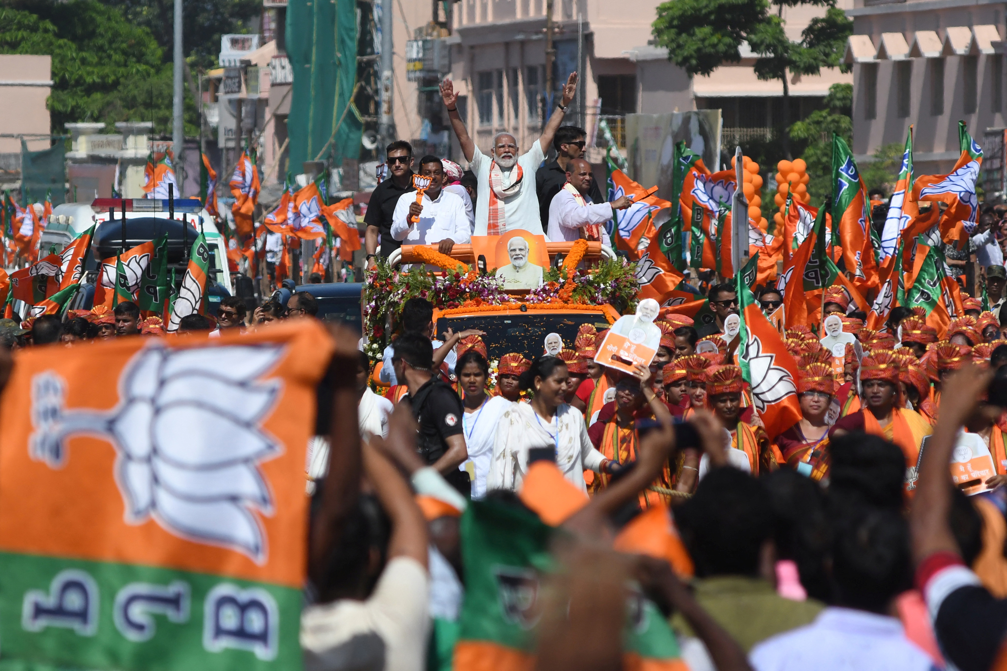 India's PM Modi waves to his supporters during a roadshow in Puri