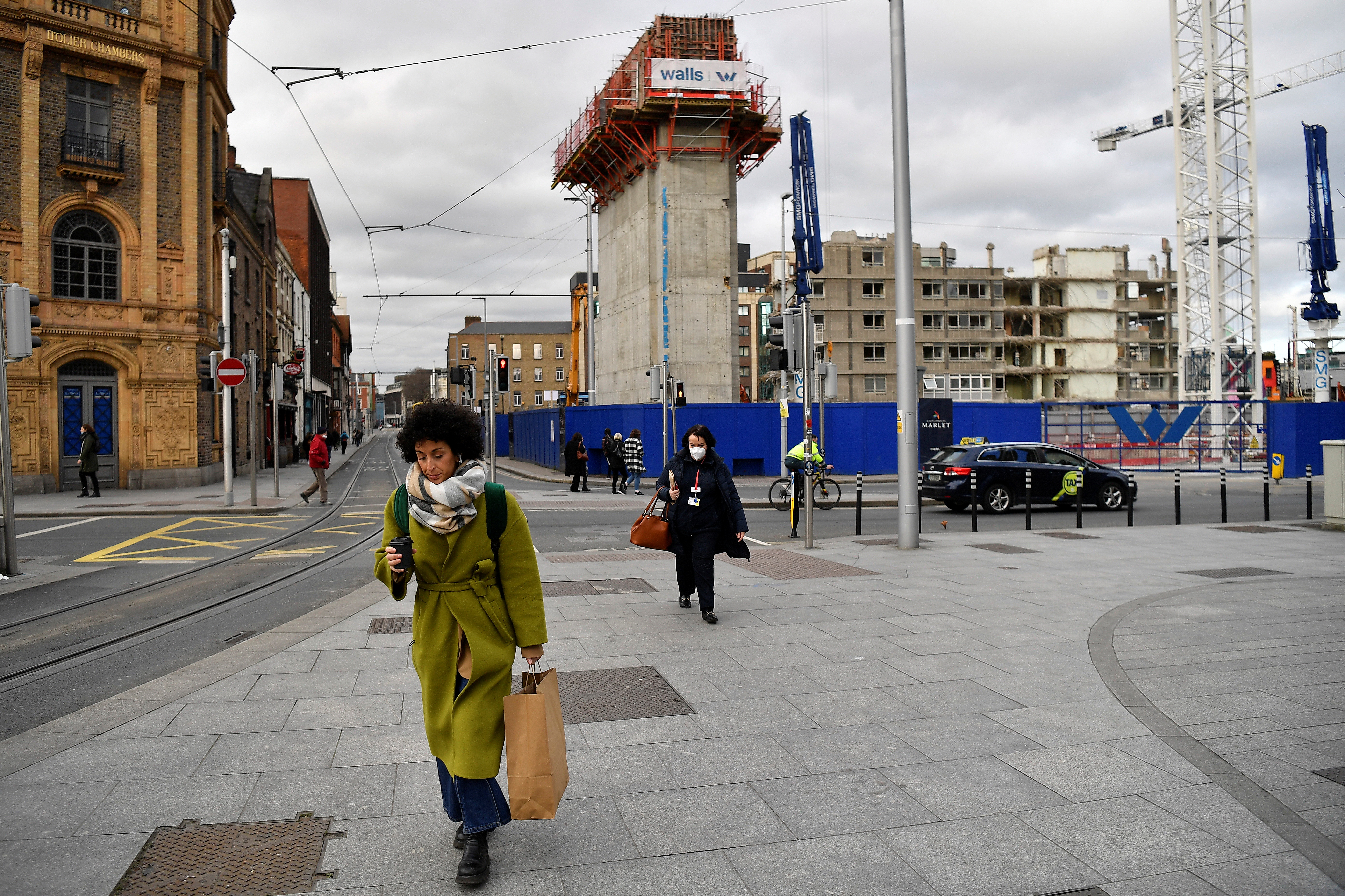 People walk near a demolition site in Dublin