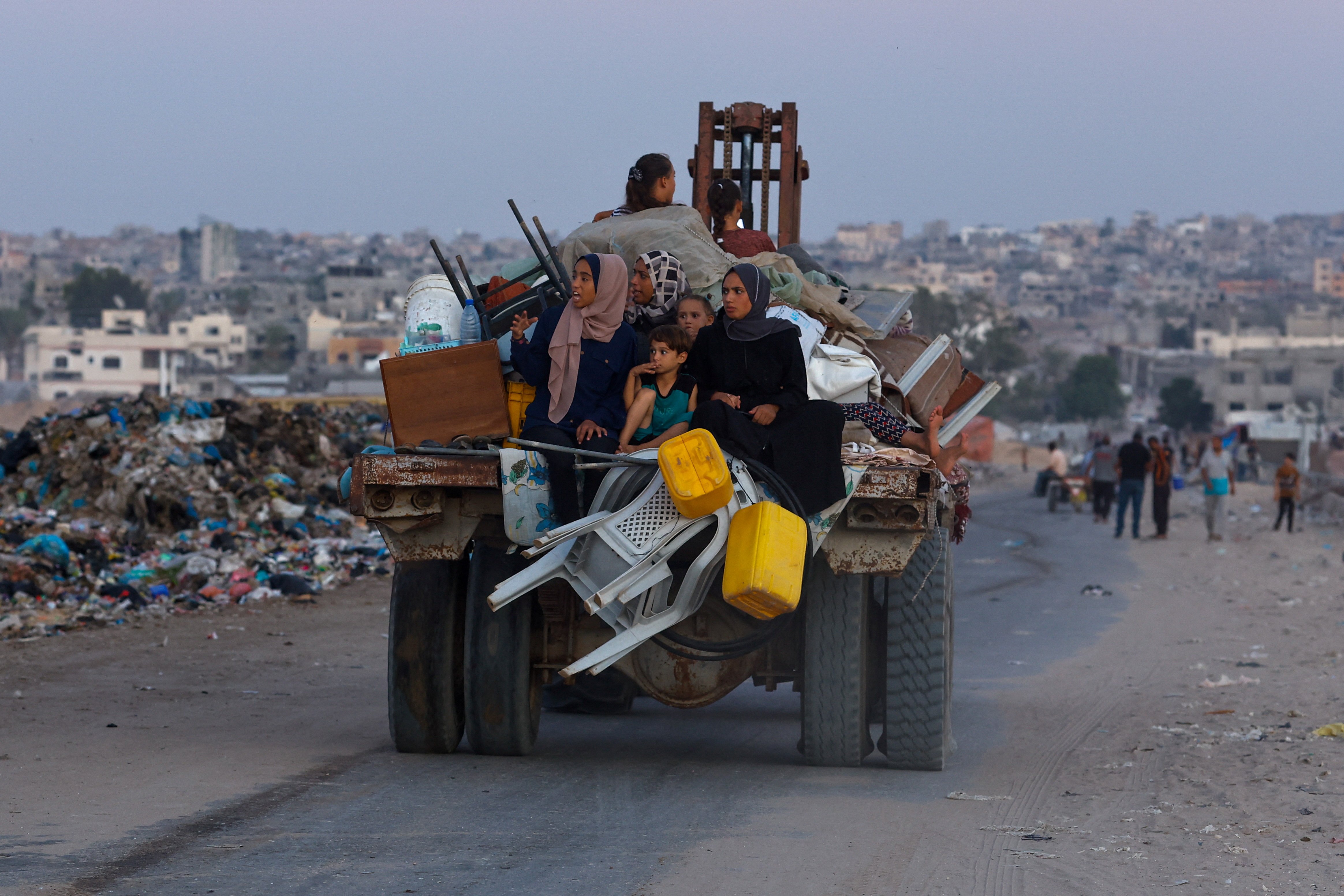 Displaced Palestinians make their way after fleeing the western part of Khan Younis, following an evacuation order by the Israeli army