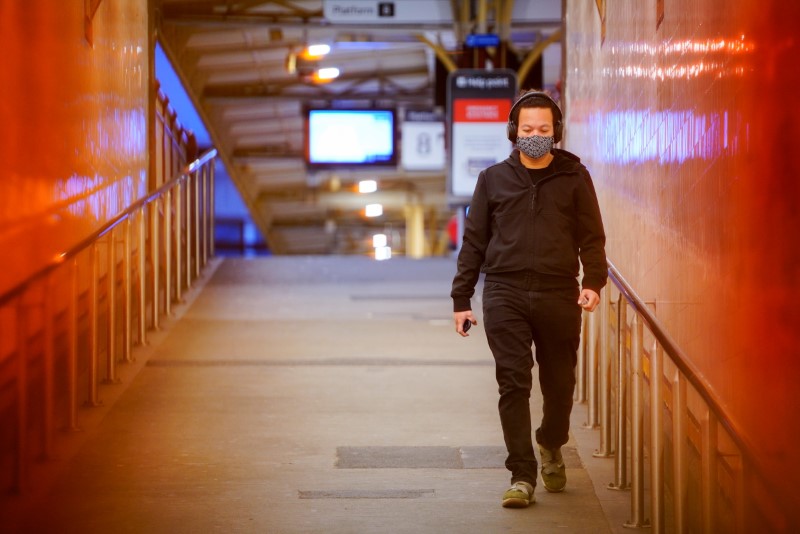 A lone passenger wearing a protective face mask walks from a deserted train platform at Flinders Street during morning commute hours on the first day of a lockdown as the state of Victoria looks to curb the spread of a coronavirus disease (COVID-19) outbreak in Melbourne, Australia, July 16, 2021.  REUTERS/Sandra Sanders