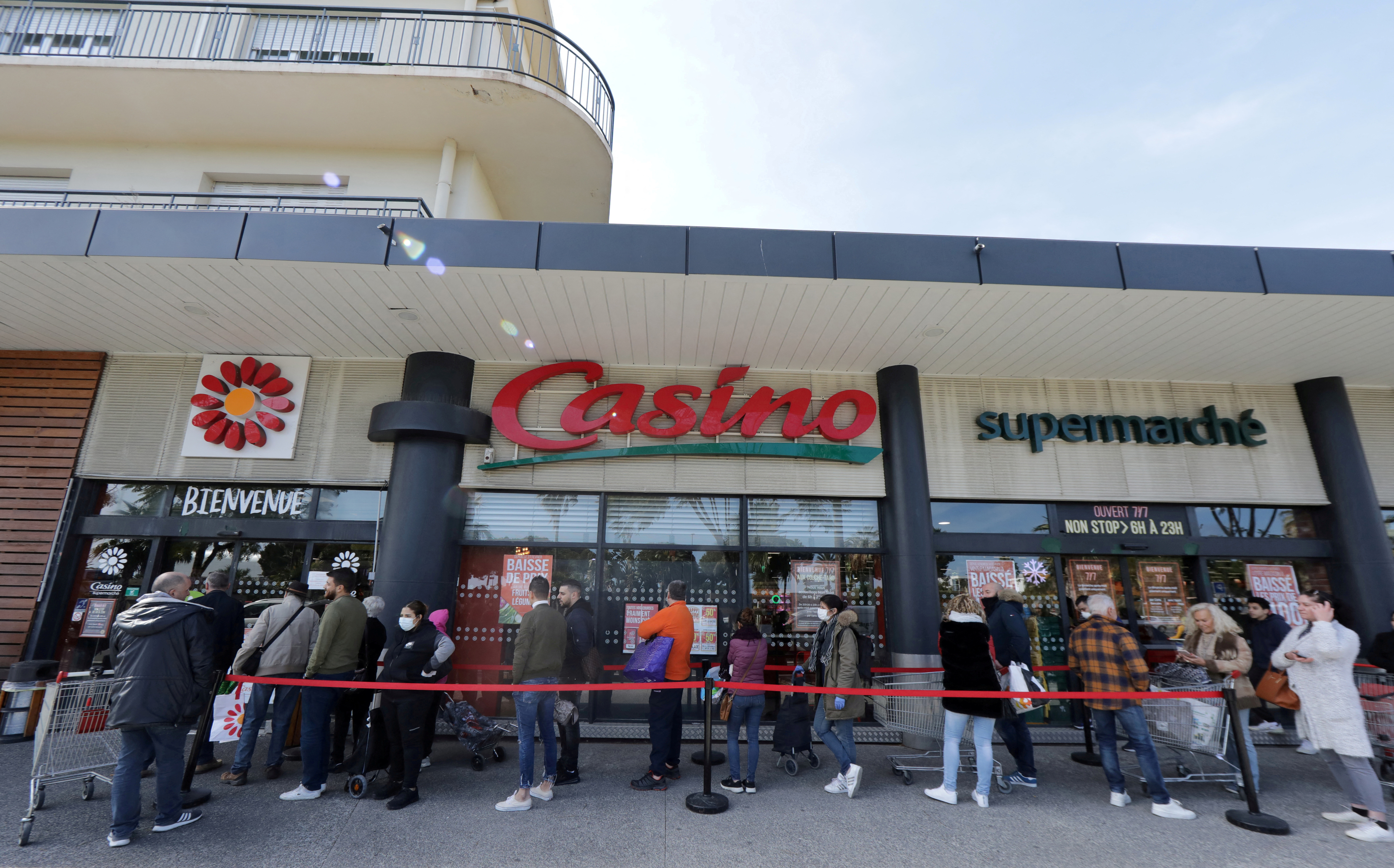 People queue to enter a Casino supermarket in Nice
