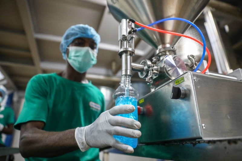 An employee fills a bottle with hand sanitizer in Cormart factory as the company steps up production of hand santizers to prevent the spread of coronavirus disease (COVID-19) in Lagos