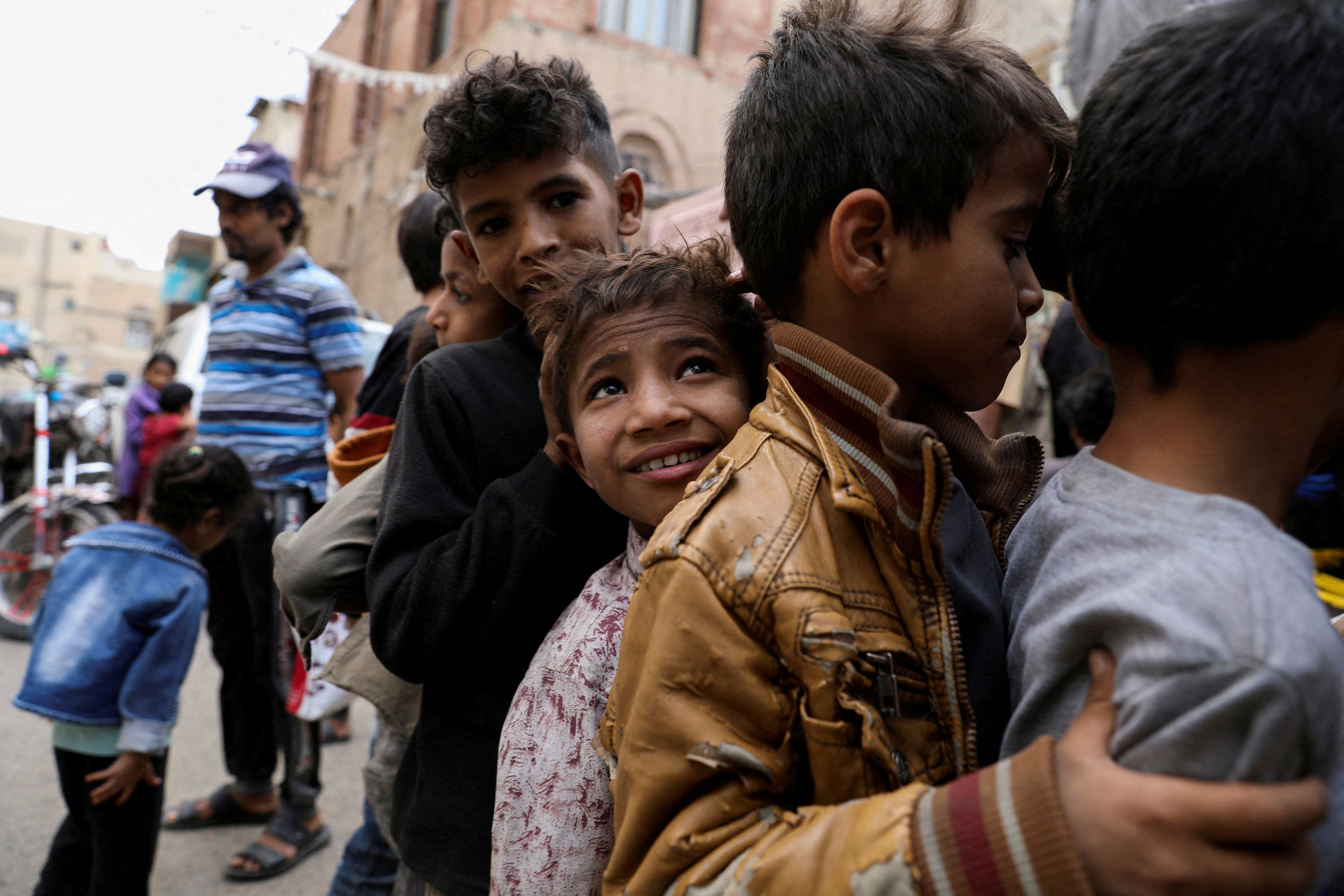 Boys stand in line as they wait to receive meals from a charity kitchen during the holy month of Ramadan in Sanaa