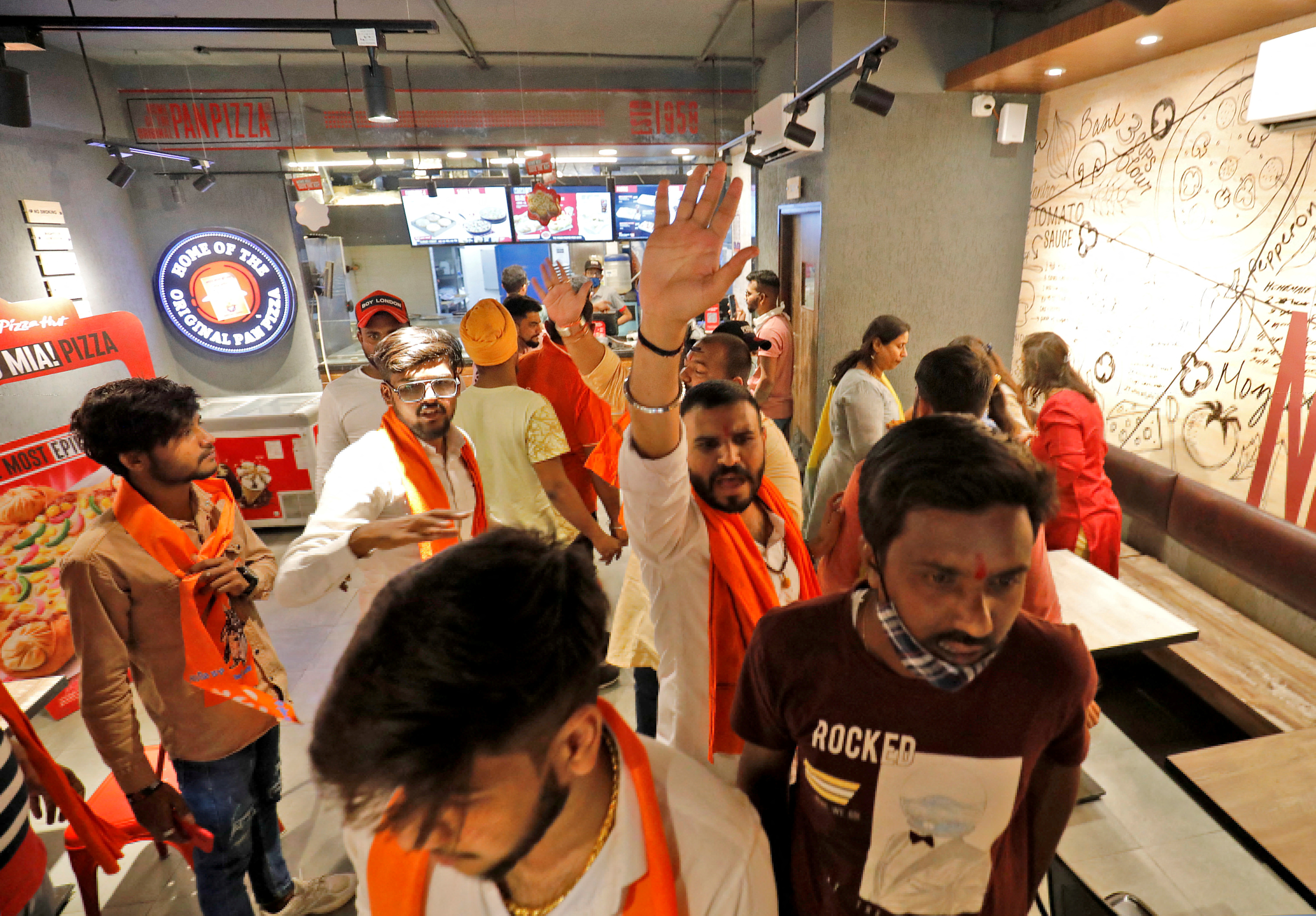 Activist of Bajrang Dal shout slogans inside a Pizza Hut food outlet during a protest in Ahmedabad