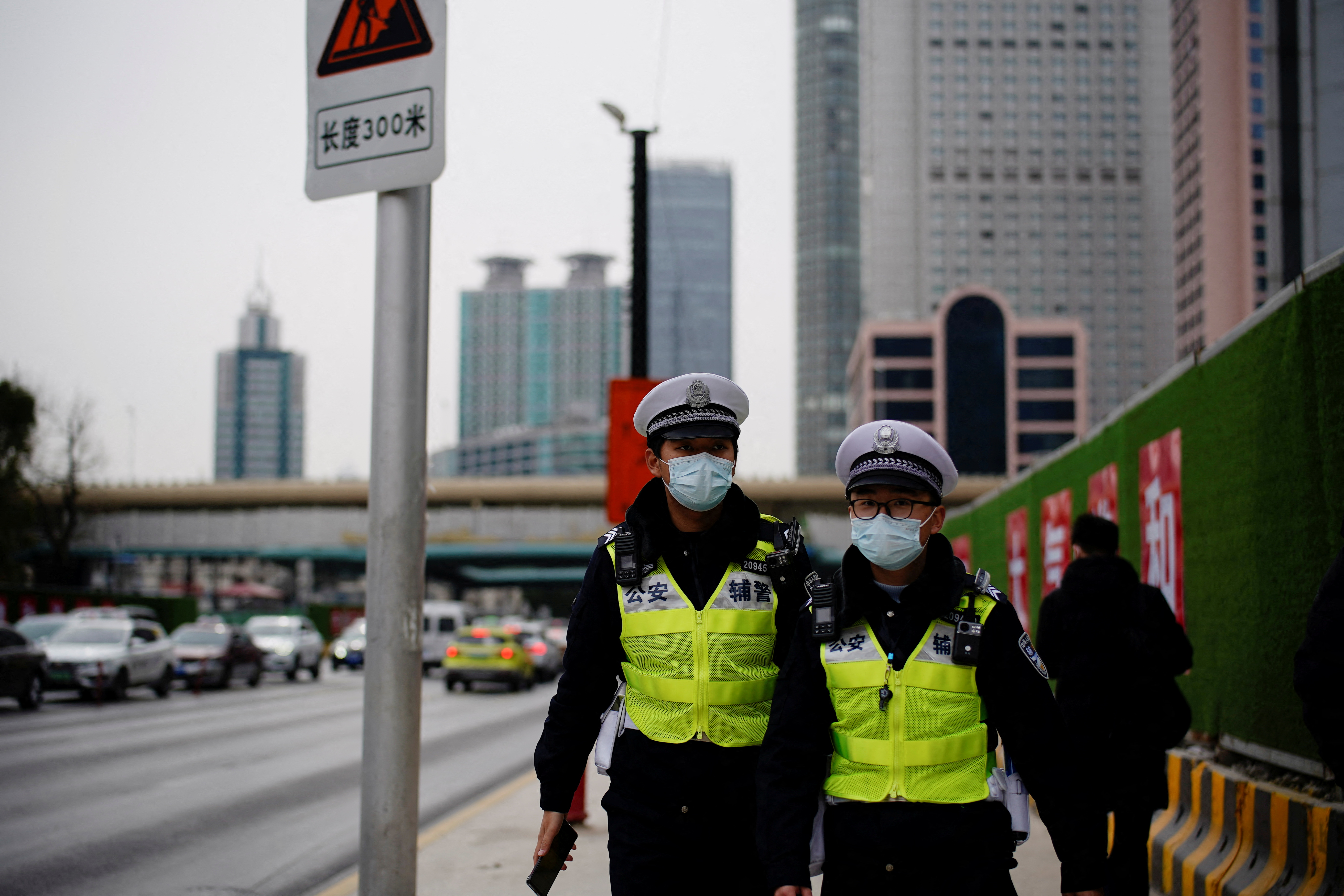 Security guards wearing protective masks walk on a street, following new cases of the coronavirus disease (COVID-19), in Shanghai