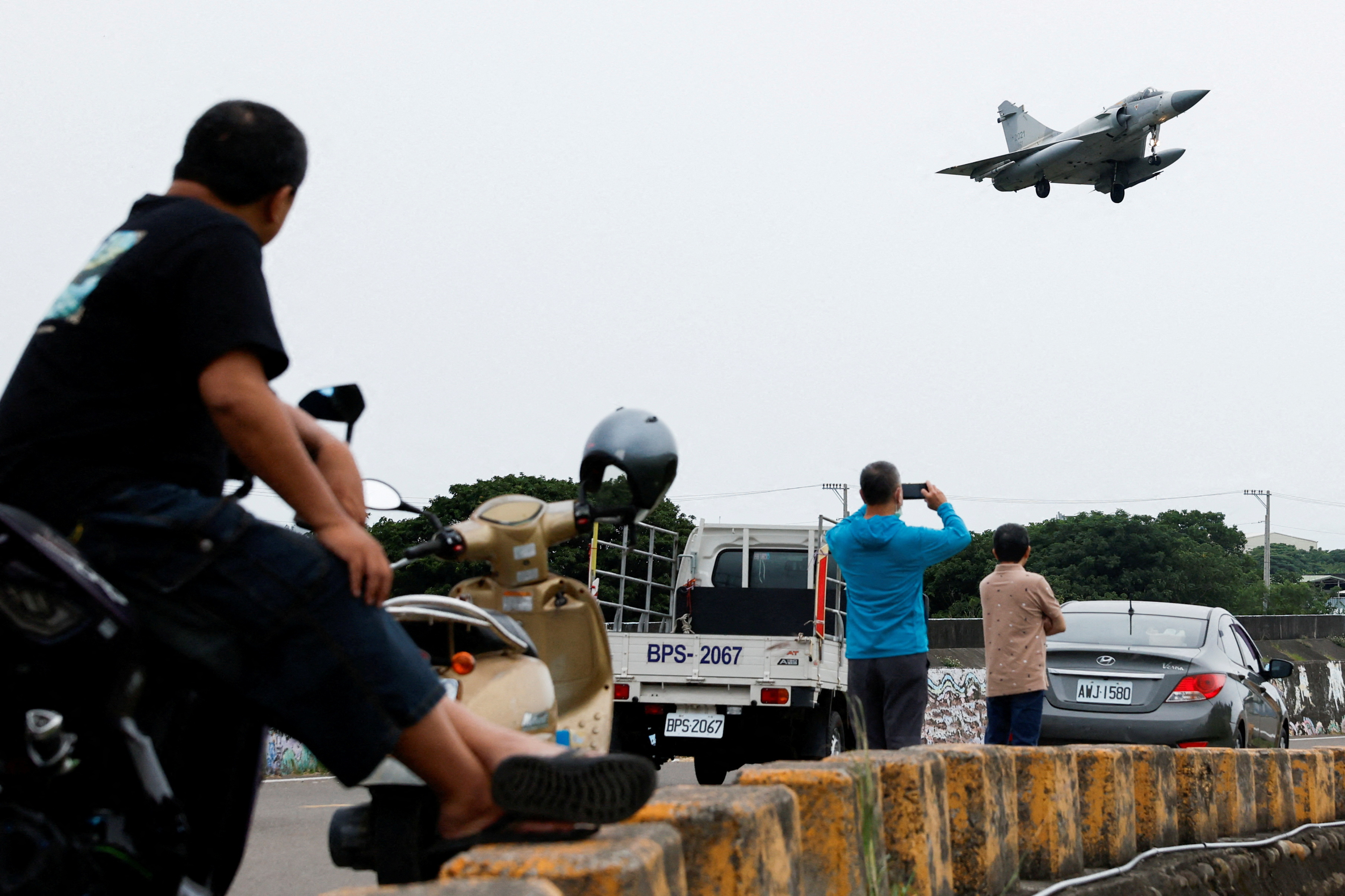 People look at a Taiwan Air Force Mirage 2000-5 aircraft as it prepares to land at Hsinchu Air Base in Hsinchu