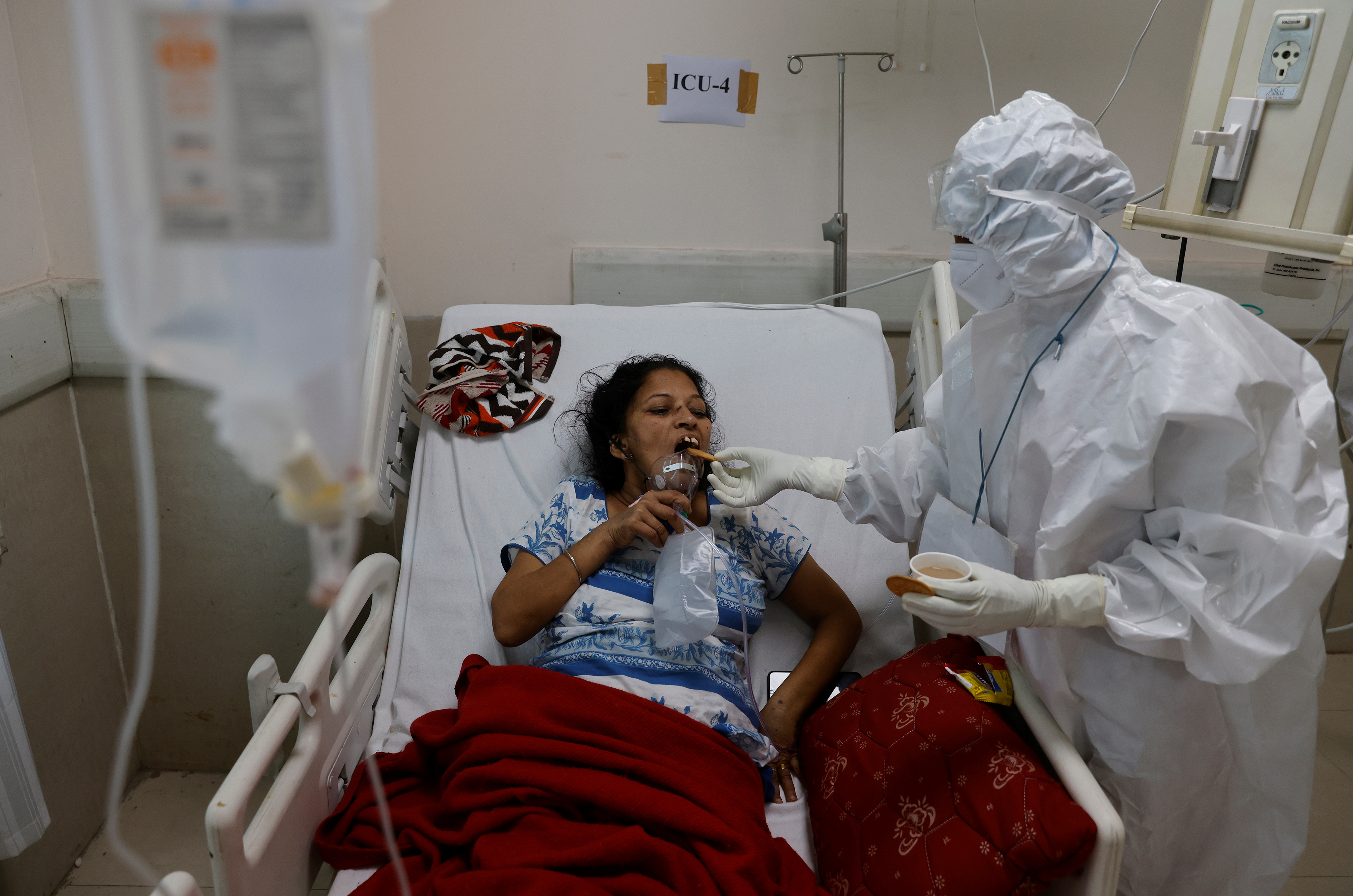 A medical worker feeds a patient suffering from the coronavirus disease (COVID-19), inside the Intensive Care Unit (ICU) ward at the Government Institute of Medical Sciences (GIMS) hospital, in Greater Noida on the outskirts of New Delhi, India, May 21, 2021. REUTERS/Adnan Abidi