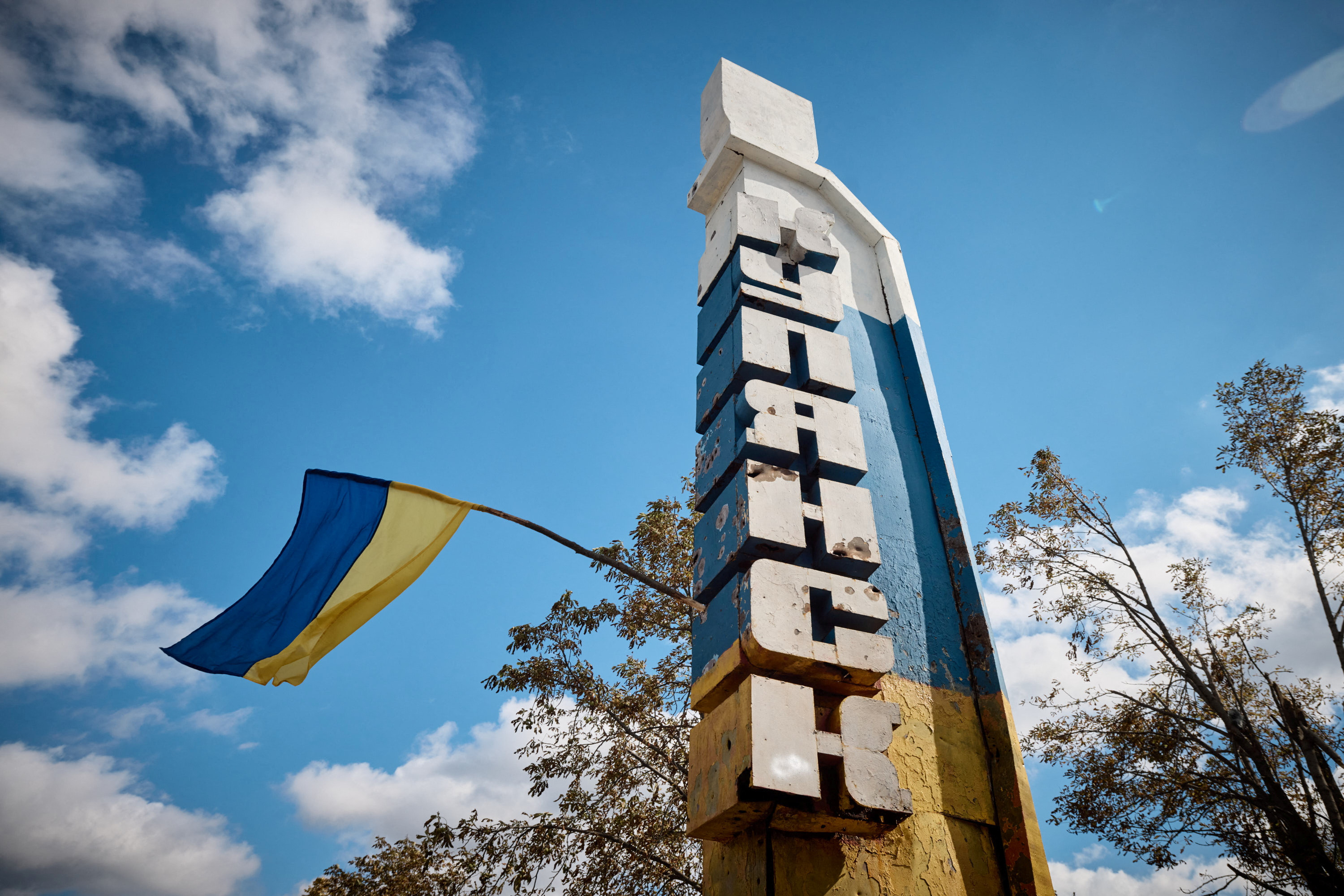 Ukrainian national flag flies on an entrance to the recently liberated town of Kupiansk