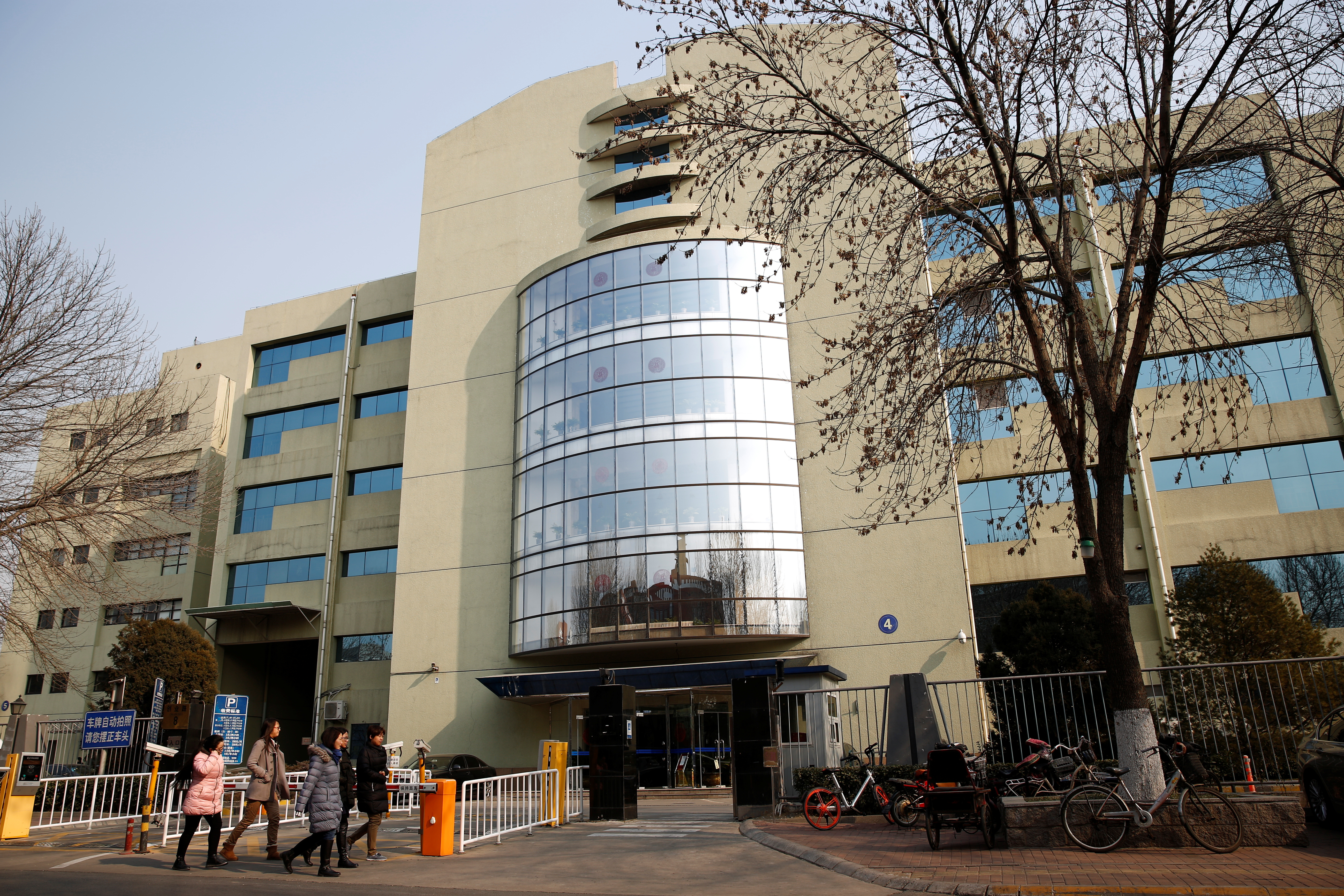 People walk past the building with the listed address of Tomorrow Holdings' Beijing office