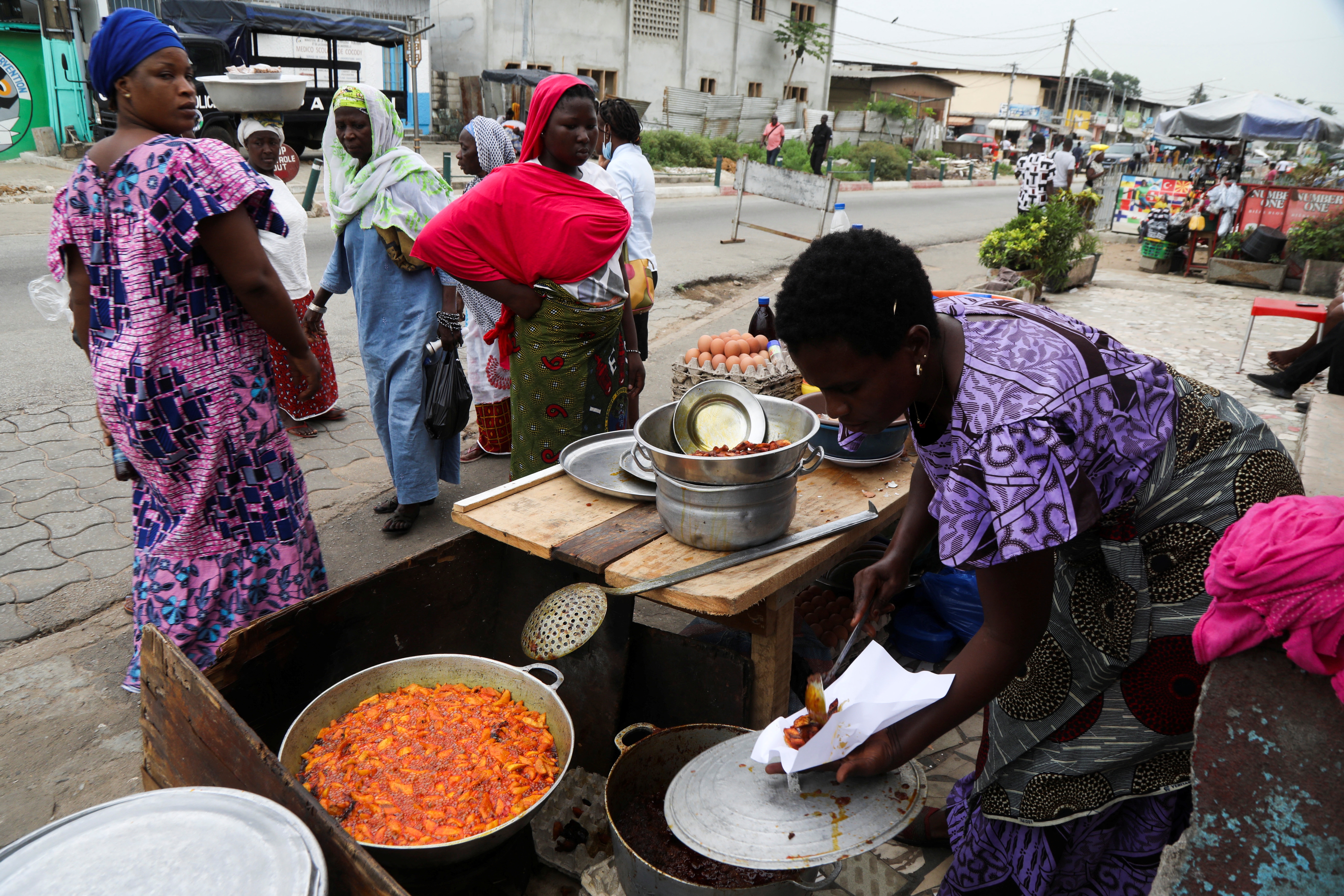 A woman sell plantains fried in crude palm oil, on a street in Abidjan